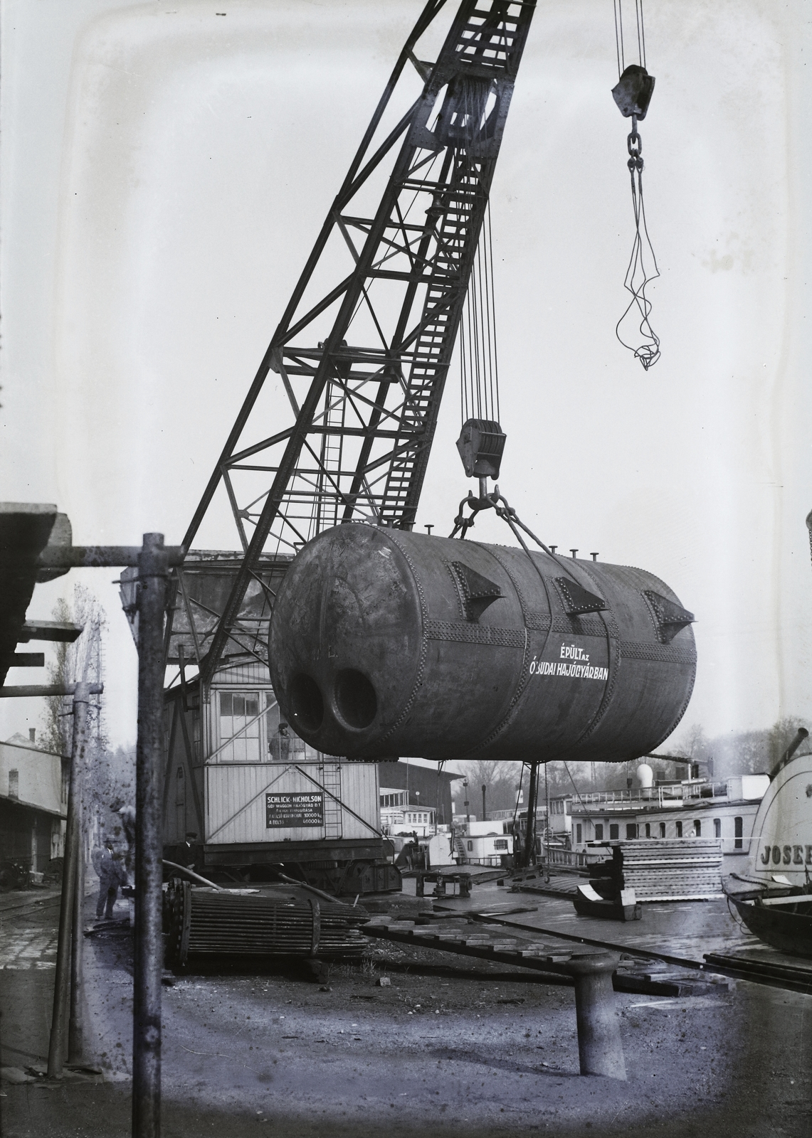 Magyarország, Óbuda, Budapest III., Óbudai Hajógyár, Hajógyári-öböl partja. A 40 tonna teherbírású daru kazánt emel egy uszály fedélzetére. Háttérben a Josef Carl lapátkerekes gőzhajó. Leltári jelzet: MMKM TFGY 2017.2.271., 1930, Magyar Műszaki és Közlekedési Múzeum / Történeti Fényképek Gyűjteménye / Óbudai Hajógyár gyűjteménye, Budapest, Fortepan #122132