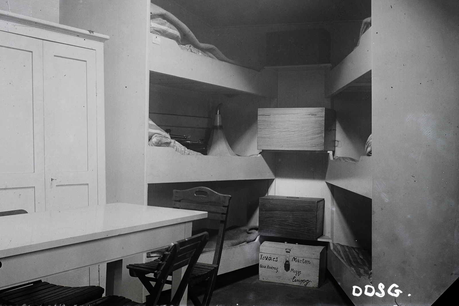 Hungary, Óbuda, Budapest III., Óbudai Hajógyár, a K. und k. Bade- und Desinfektionsschiff "E" kabinja (állatszállító DDSG uszály kórházhajóvá alakítva). Leltári jelzet: MMKM TFGY 2017.2.923., 1917, Magyar Műszaki és Közlekedési Múzeum / Történeti Fényképek Gyűjteménye / Óbudai Hajógyár gyűjteménye, ship, barge, table, chest, blanket, footlocker, makeshift bed, Budapest, folding chair, Fortepan #122464