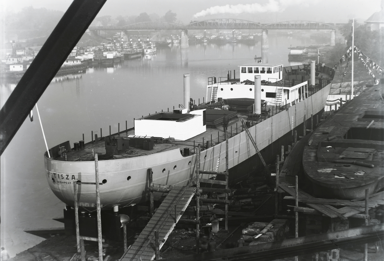 Hungary, Budapest XIII., Újpesti-öböl, szemben az Újpesti vasúti híd. Ganz és Tsa. Villamossági-, Gép-, Waggon- és Hajógyár Rt. A DTRT Tisza (1937) Duna-tengerjáró áruszállító hajó a sólyán. Leltári jelzet: MMKM TFGY 2017.1.202., 1937, Magyar Műszaki és Közlekedési Múzeum / Történeti Fényképek Gyűjteménye / Ganz gyűjtemény, Budapest, Fortepan #122600