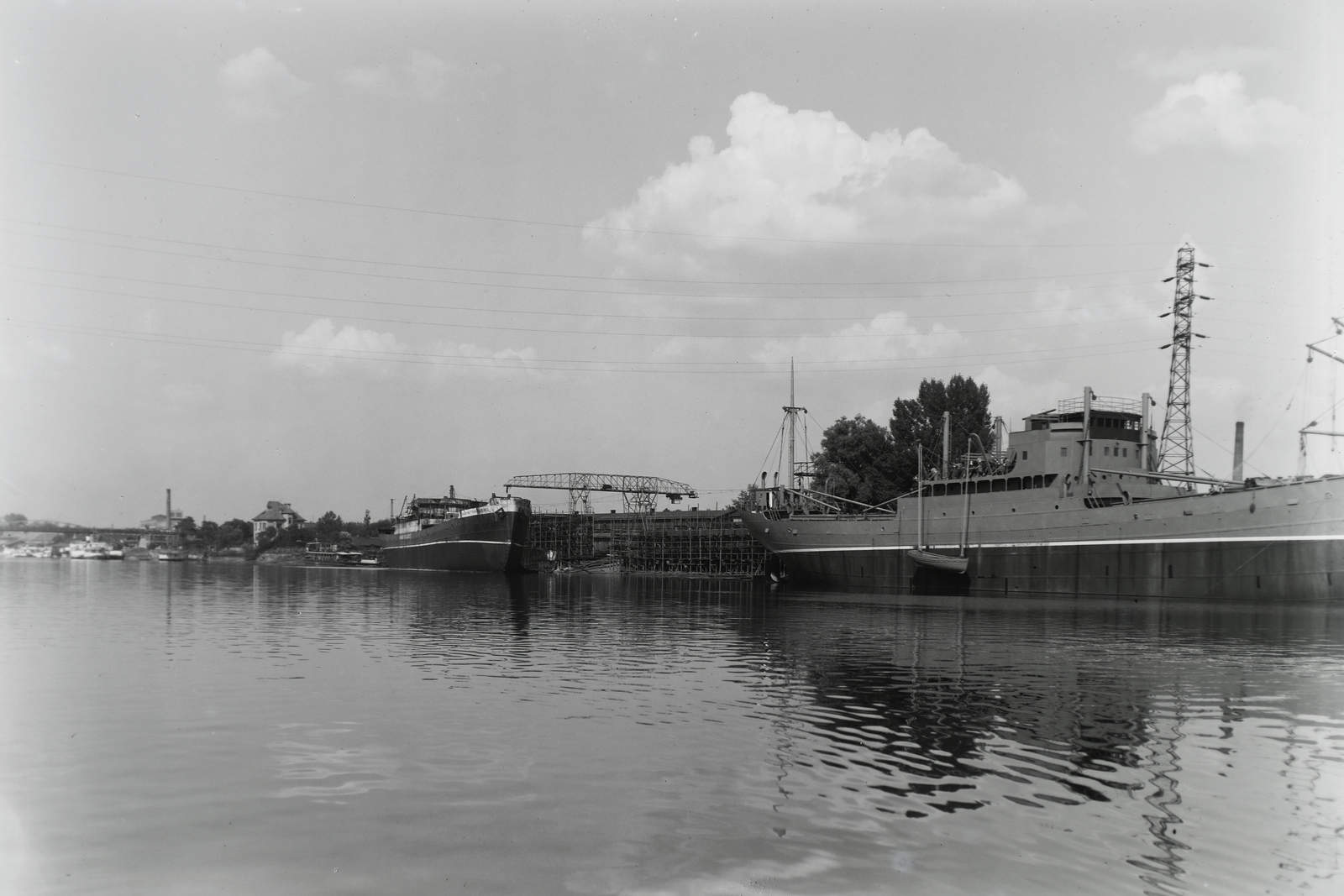 Magyarország, Budapest XIII., Újpesti-öböl, Ganz és Tsa. Villamossági-, Gép-, Waggon- és Hajógyár Rt. A Magyar Vitéz (1942) mögötte a Magyar Tengerész (1942) közöttük feltehetően a DTRT Komárom (1944) és a Szolnok (később Manics, 1947) tengeri áruszállító csavaros motorhajók építése. Leltári jelzet: MMKM TFGY 2017.1.877., 1943, Magyar Műszaki és Közlekedési Múzeum / Történeti Fényképek Gyűjteménye / Ganz gyűjtemény, Budapest, Fortepan #122913