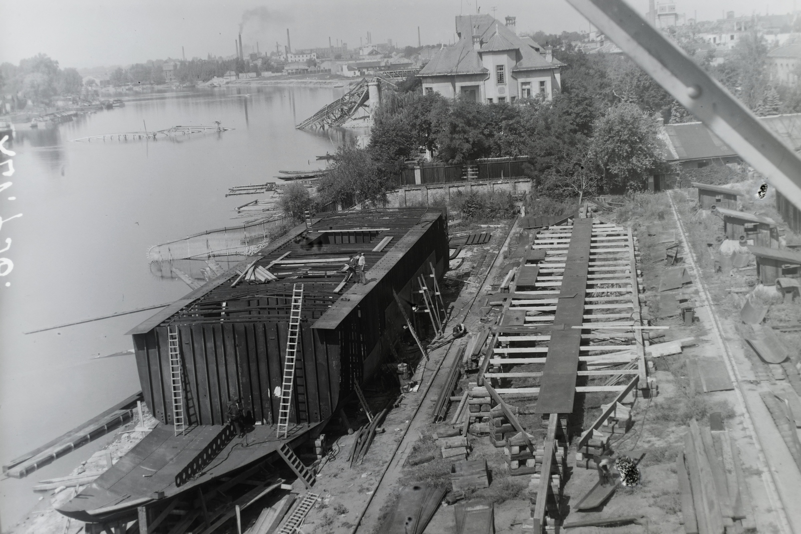 Hungary, Budapest XIII., Újpesti-öböl, háttérben a lerombolt Újpesti vasúti híd. Ganz és Tsa. Villamossági-, Gép-, Waggon- és Hajógyár Rt., a jóvátételre gyártott Szimeiz (1946) és Koreiz (1946) Duna-tengerjáró motorhajók építése. Leltári jelzet: MMKM TFGY 2017.1.923., 1945, Magyar Műszaki és Közlekedési Múzeum / Történeti Fényképek Gyűjteménye / Ganz gyűjtemény, Budapest, Fortepan #122920