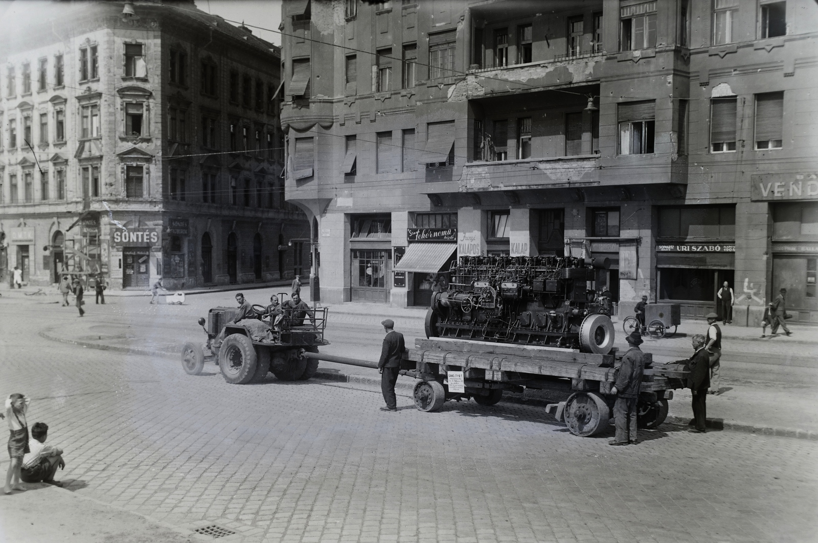 Hungary, Budapest VIII., Kálvária tér, szemben a Karácsony Sándor utca. Jendrassik-motor szállítása a Ganz kőbányai gyárából a hajógyárba. Leltári jelzet: MMKM TFGY 2017.1.1173., 1947, Magyar Műszaki és Közlekedési Múzeum / Történeti Fényképek Gyűjteménye / Ganz gyűjtemény, Budapest, trailer, engine, tractor, tricycle, Fortepan #122982