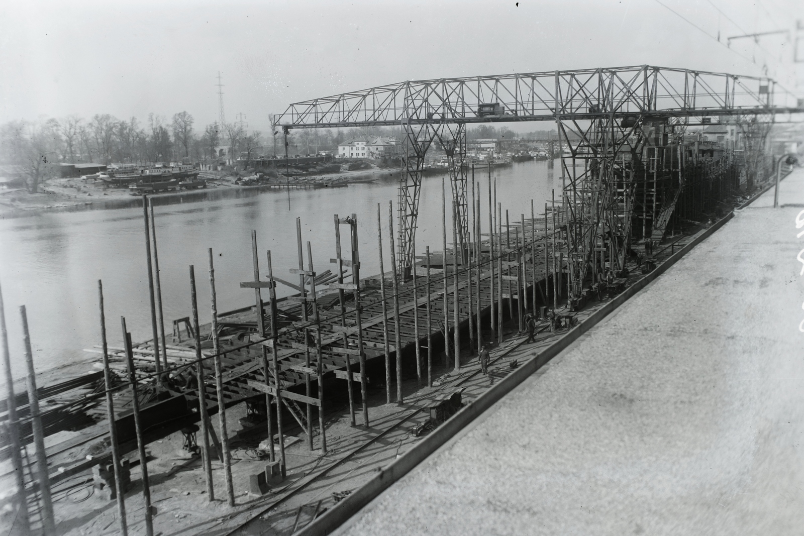 Hungary, Budapest XIII., Újpesti-öböl, a Ganz Hajógyár sólyája, a Szergej Tyulenin (1950) 1100 tonnás tengeri áruszállító csavaros motorhajó, előtte ismeretlen testvérhajója. Leltári jelzet: MMKM TFGY 2017.1.1427., 1950, Magyar Műszaki és Közlekedési Múzeum / Történeti Fényképek Gyűjteménye / Ganz gyűjtemény, Budapest, gantry crane, Fortepan #123081