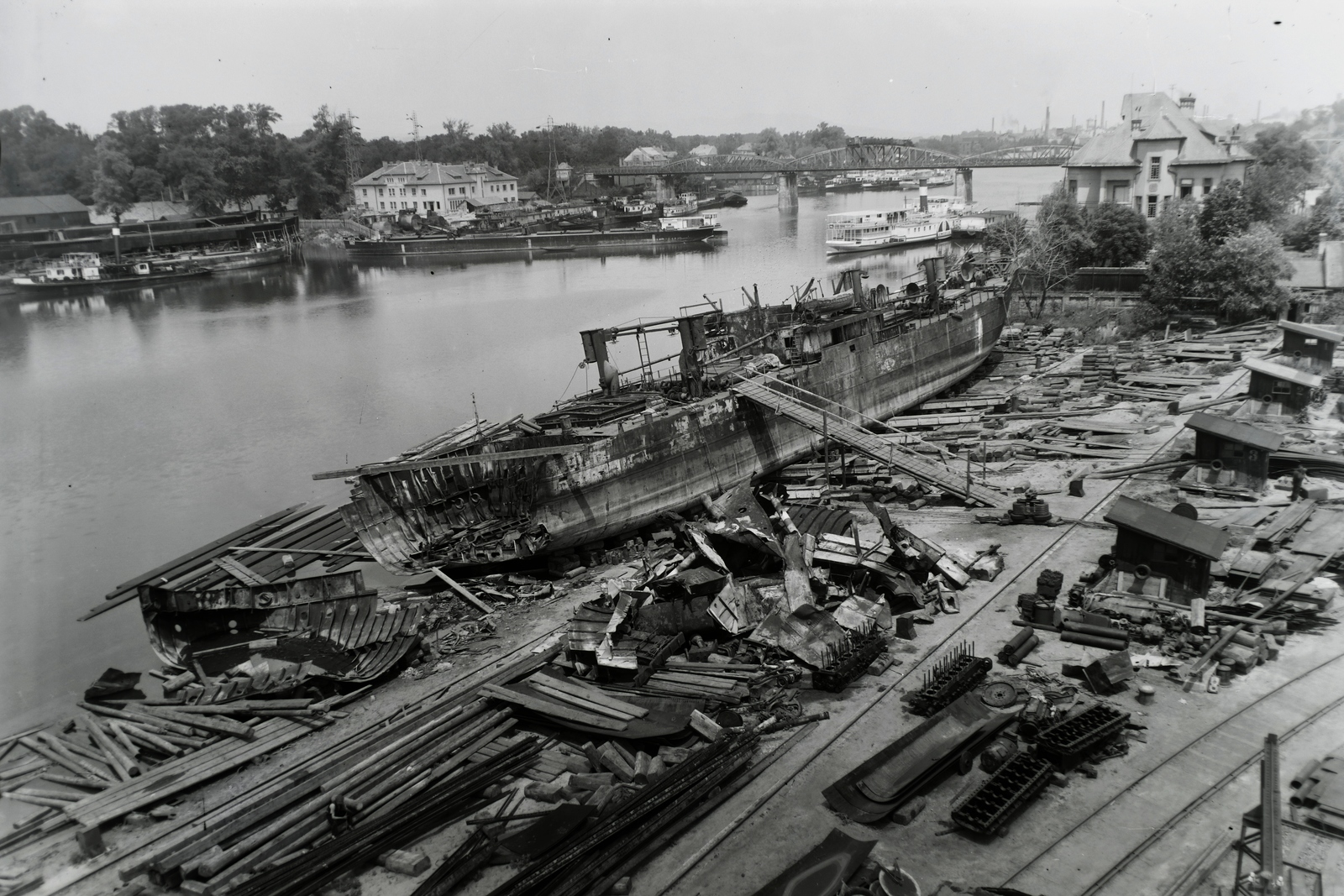 Hungary, Budapest XIII., Újpesti-öböl, Ganz és Tsa. Villamossági-, Gép-, Waggon- és Hajógyár Rt. A DTRT Kolozsvár (1941) Duna-tengeri áruszállító csavaros motorhajó /ép. 1941/ a hajót ért 1943.I.22-i fekete-tengeri kiégés után Budapesten javítás alatt, háttérben az MFTR Zsófia (1914) sétahajó. Leltári jelzet: MMKM TFGY 2017.1.803., 1943, Magyar Műszaki és Közlekedési Múzeum / Történeti Fényképek Gyűjteménye / Ganz gyűjtemény, Budapest, Fortepan #123140
