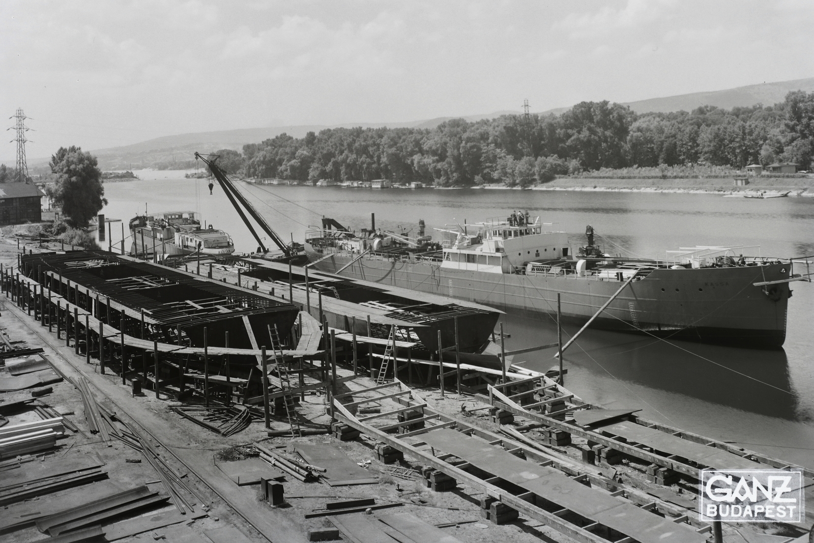 Hungary, Budapest XIII., Újpesti-öböl, Ganz és Tsa. Villamossági-, Gép-, Waggon- és Hajógyár Rt. Jobbra a DTRT Kassa (1939) Duna-tengerjáró áruszállító hajó, mögötte az Újpest (1906) úszódaru, majd a Magyar (1939) áruszállító csavaros motorhajó (paklishajó). Leltári jelzet: MMKM TFGY 2017.1.418., 1939, Magyar Műszaki és Közlekedési Múzeum / Történeti Fényképek Gyűjteménye / Ganz gyűjtemény, Budapest, Fortepan #123170