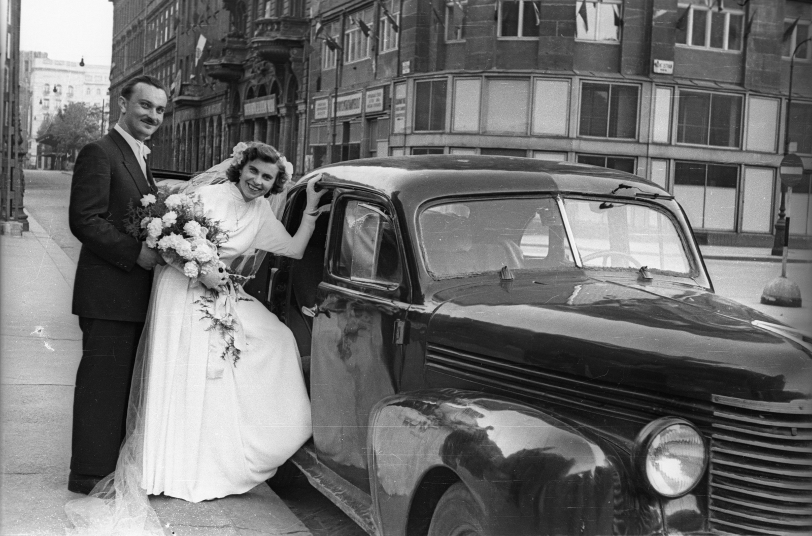 Hungary, Budapest V., Szent István tér, a felvétel a Szent István-bazilika előtt készült. Balra a Hercegprímás (Wekerle Sándor) utca, távolban az Erzsébet (Sztálin) tér, a MÁVAUT autóbusz-pályaudvar., 1951, Hámori Gyula, bride, groom, Budapest, entering the car, Fortepan #123288