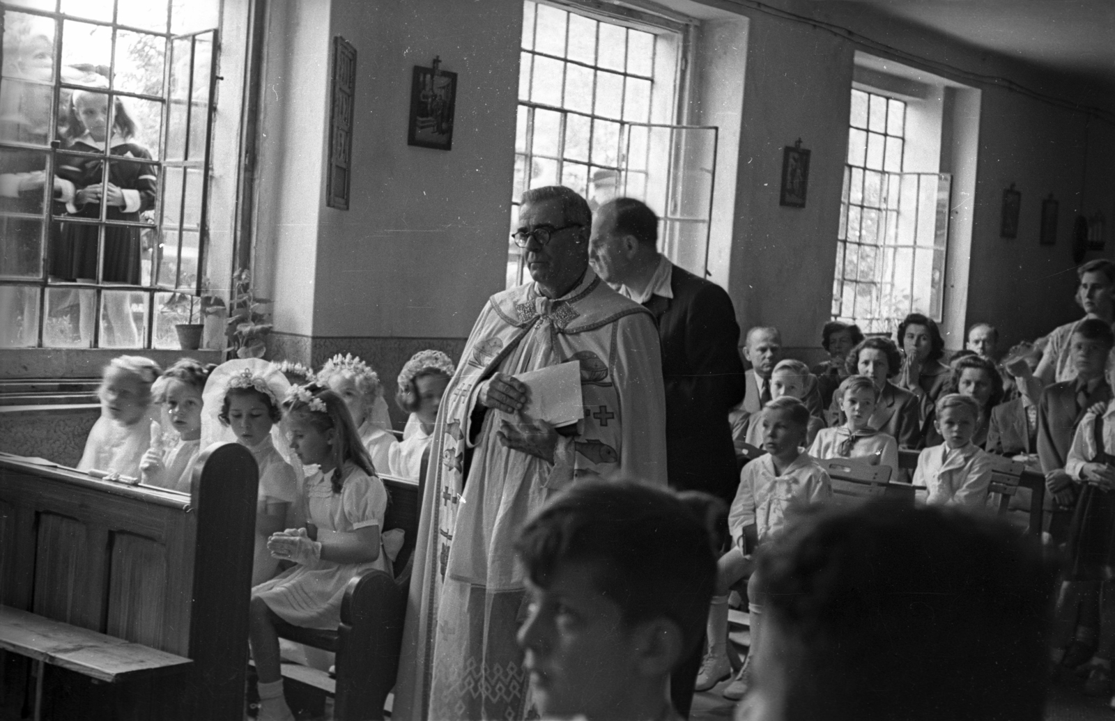 Magyarország, Budapest XII., Hegyalja út 139., az egykori vendéglő helyén kialakított templom, elsőáldozók., 1954, Hámori Gyula, Budapest, ablak, templombelső, gyerekek, leselkedő, pap, kíváncsiság, Fortepan #123584