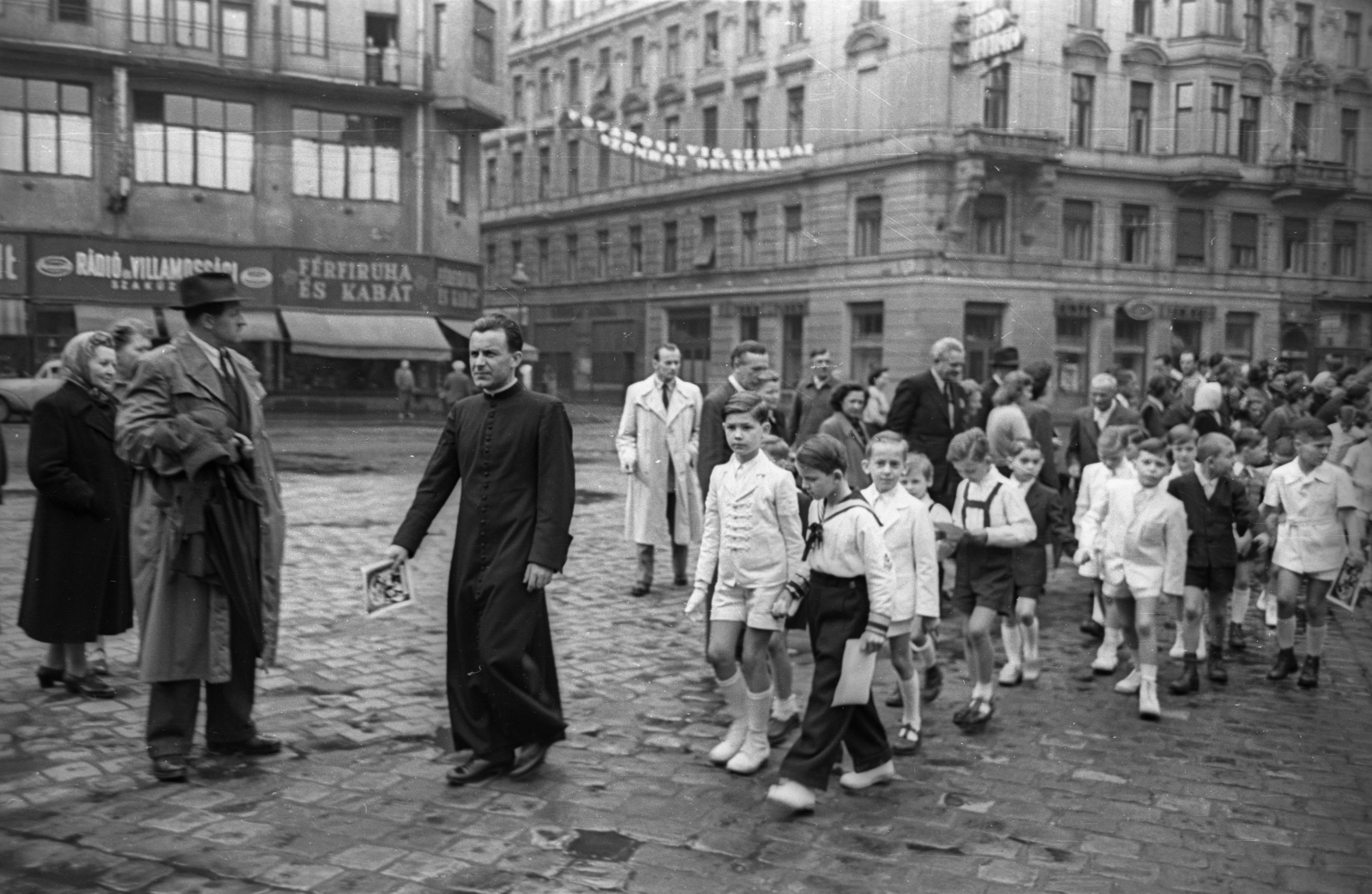 Hungary, Budapest VIII.,Budapest VII., Rákóczi út, szemben a Nyár utca, elsőáldozók a Szent Rókus-kápolna előtt., 1956, Hámori Gyula, Budapest, shorts, boys, priest, cassock, Fortepan #123649