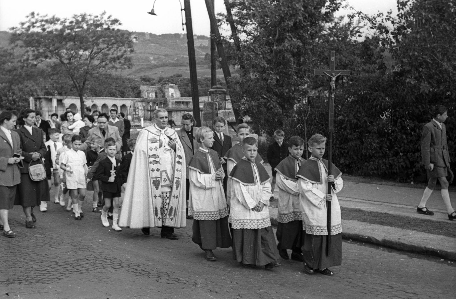Magyarország, Budapest XII., elsőáldozók a Hegyalja úton, háttérben a Németvölgyi út és a lerombolt Keresztes Szent János-temetőkápolna a Farkasréti temetőben., 1956, Hámori Gyula, Budapest, hordozás, feszület, ministráns, ornátus, Fortepan #123693