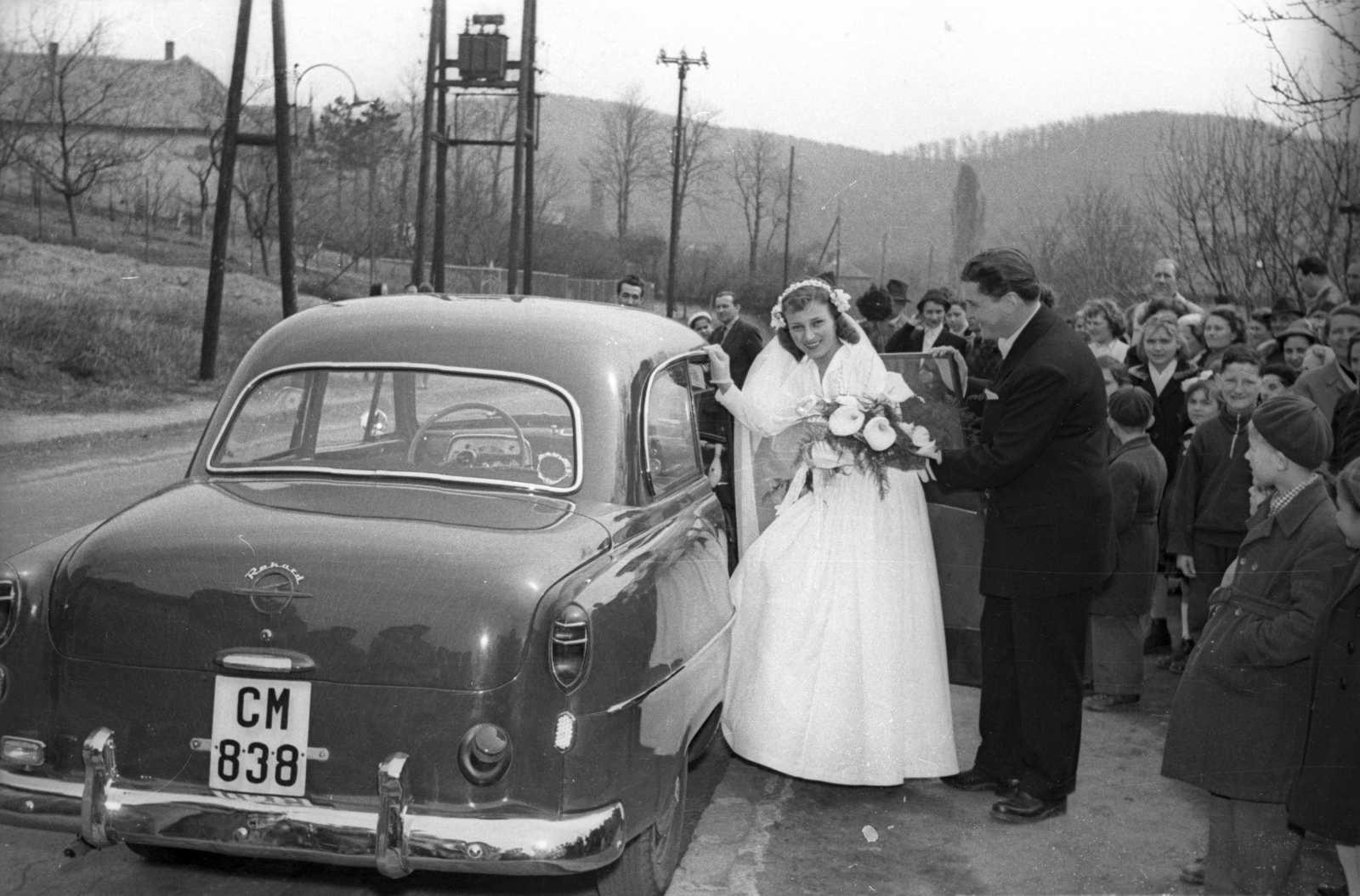 Magyarország, Budapest II., Máriaremetei (Dimitrov) út a Remetekertvárosi Szentlélek templom előtt. Távolban a Vadaskerti-hegy és a Nyéki-hegy látszik., 1957, Hámori Gyula, Opel-márka, menyasszony, vőlegény, Opel Rekord, Budapest, Opel Olympia 1955, rendszám, Fortepan #123750