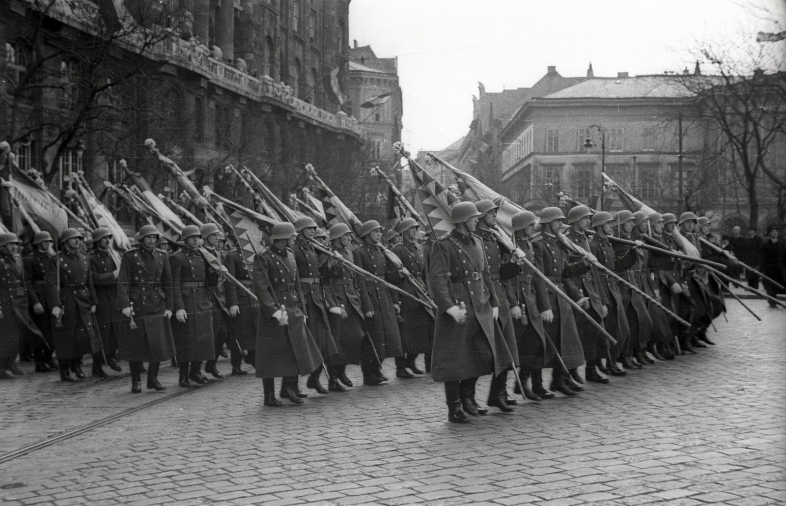 Hungary, Budapest V., Széchenyi István (Ferenc József) tér a Pesti Magyar Kereskedelmi Bank székháza (később Belügyminisztérium) előtt. A Bólyai Akadémia díszszázada a Szovjetunióból hazahozott 1848-as honvédzászlókkal, a felvétel 1941. március 24-én készült. Háttérben a Dorottya utca sarkán a Lloyd palota., 1941, Lenkey Márton, palace, Classicism, József Hild-design, Budapest, Fortepan #124061