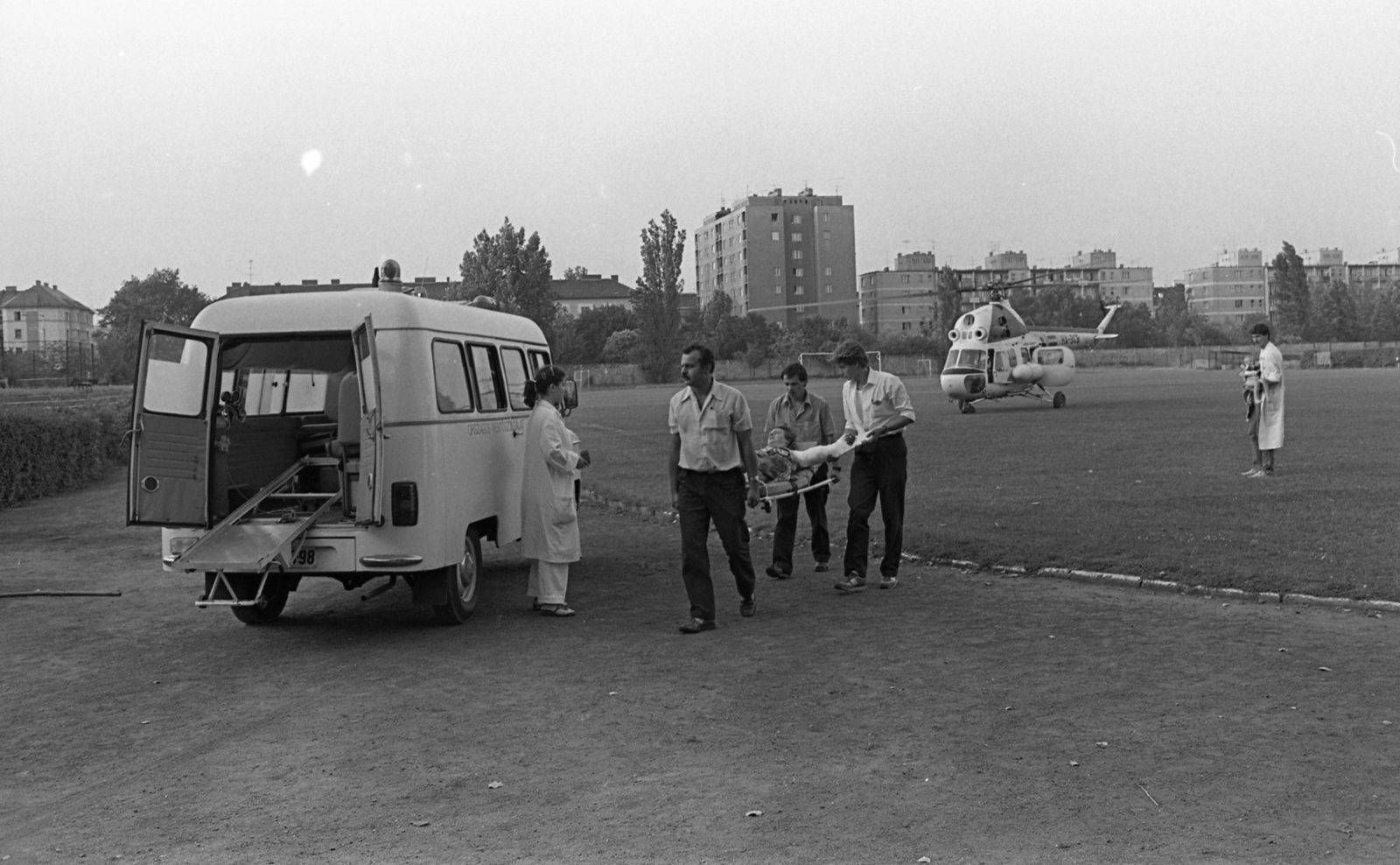 Hungary, Budapest XIII., Lomb (Vágó Béla) utca - Rozsnyai utca sarok, Láng Vasas sporttelep. Az Országos Mentőszolgálat mentőhelikoptere mögött a Tahi utcai lakótelep látszik., 1986, Urbán Tamás, Nysa-brand, ambulance, helicopter, Mil-brand, Budapest, Fortepan #124560