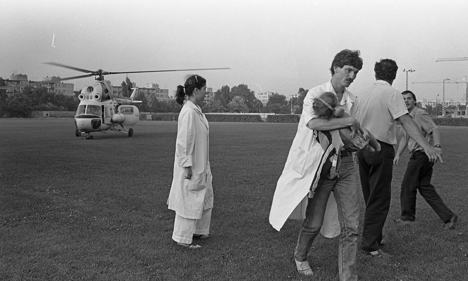 Hungary, Budapest XIII., Lomb (Vágó Béla) utca - Rozsnyai utca sarok, Láng Vasas sporttelep. Az Országos Mentőszolgálat mentőhelikoptere mögött a Tahi utcai lakótelep látszik., 1986, Urbán Tamás, helicopter, Mil-brand, Budapest, Fortepan #124566