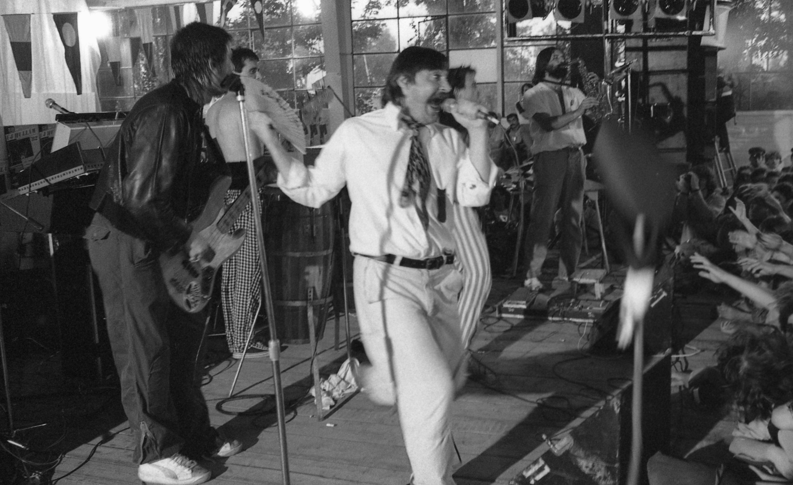 Hungary, Balatonfüred, a Magyar Hajó- és Darugyár Balatonfüredi Gyáregységének szerelőcsarnoka, Újhullámos Fesztivál 1982. augusztus 7-én. Az erre az alkalomra alakult Árnyékszék zenekar, az új hullámos paródiát bemutató együttes tagjai Trunkos András, feLugossy László, takarva csikos nadrágban Nagy Feró és szaxofonnal Wahorn András., 1982, Urbán Tamás, Fortepan #124871