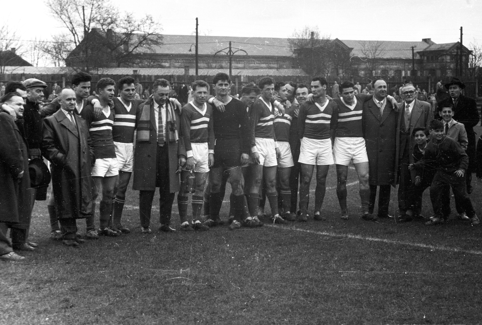 Hungary, Budapest X., Kőbányai út 45., MÁVAG Sporttelep, háttérben a MÁV Északi Járműjavító Üzem egyik épülete., 1958, Bauer Sándor, Budapest, arms around shoulders, soccer team, boys, Fortepan #127638