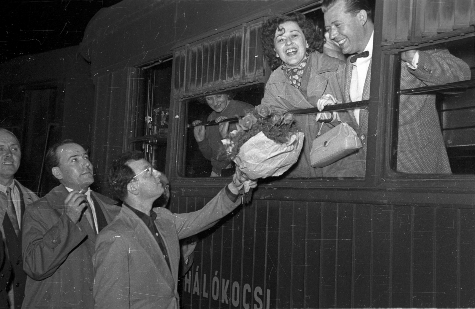 Hungary, Budapest VI., Nyugati pályaudvar, a Szovjetunióba utazó negyventagú esztrádegyüttes szereplői közül az ablakban a Záray Márta és Vámosi János énekes házaspár. A virágcsokrot Majláth Jenő zeneszerző, énekes nyújtja át., 1956, Bauer Sándor, celebrity, Budapest, Fortepan #127776