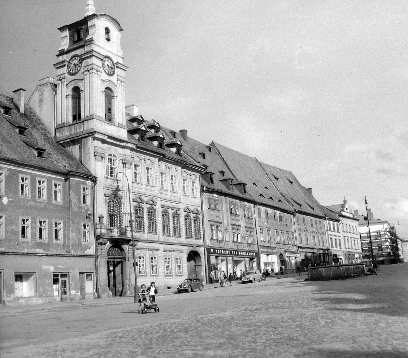 Csehország, Cheb, náměstí Krále Jiřího z Poděbrad, szemben az Új Városháza., 1958, Gyöngyi, Csehszlovákia, babakocsi, lámpaoszlop, üzletportál, automobil, toronyóra, főtér, Fortepan #12781