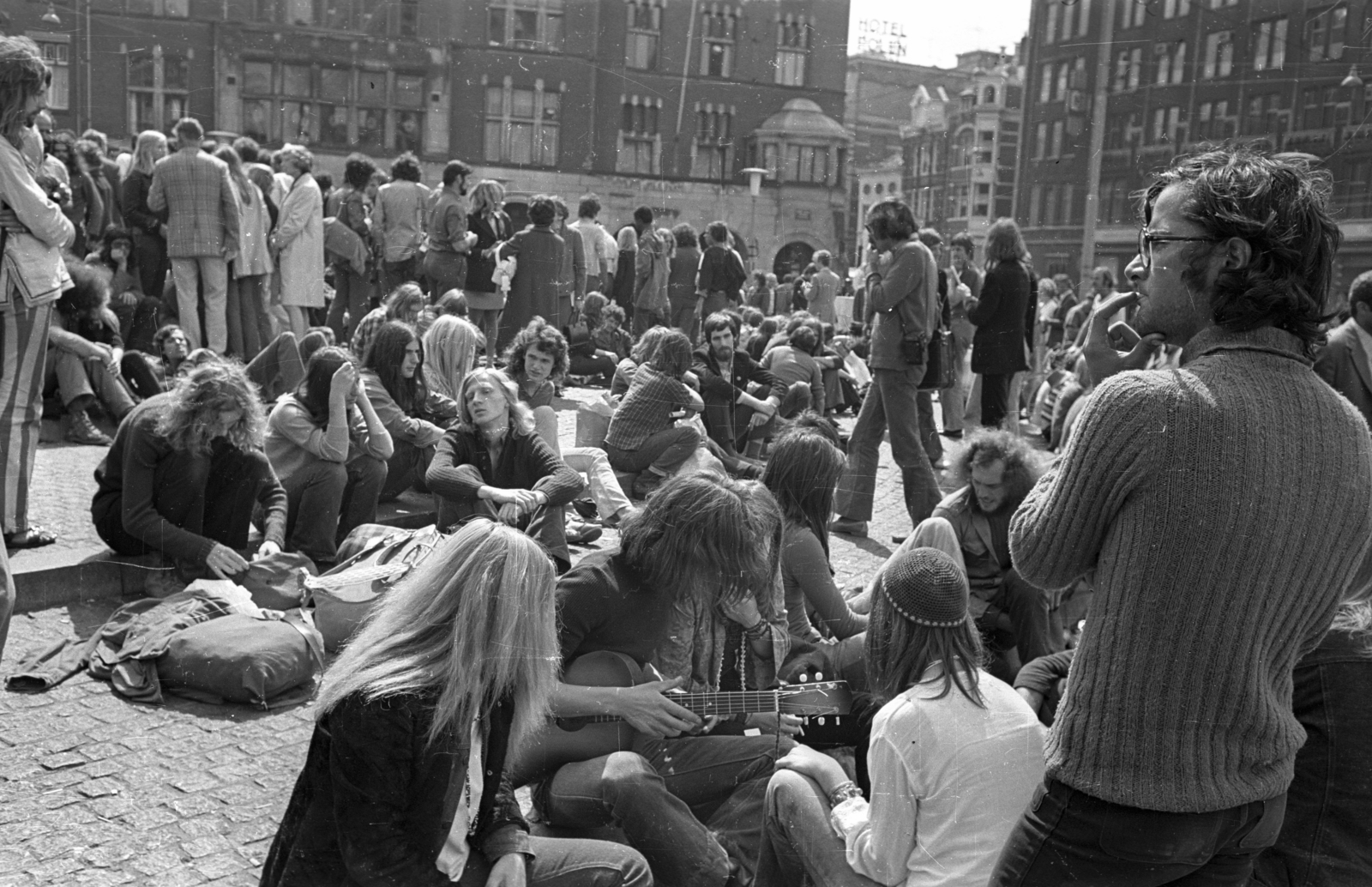 Netherlands, Amsterdam, Dam tér, a felvétel a Nemzeti Emlékmű előtt készült, szemben a Rokin sarkán álló ház., 1972, Bauer Sándor, hippie, guitar, Fortepan #128377