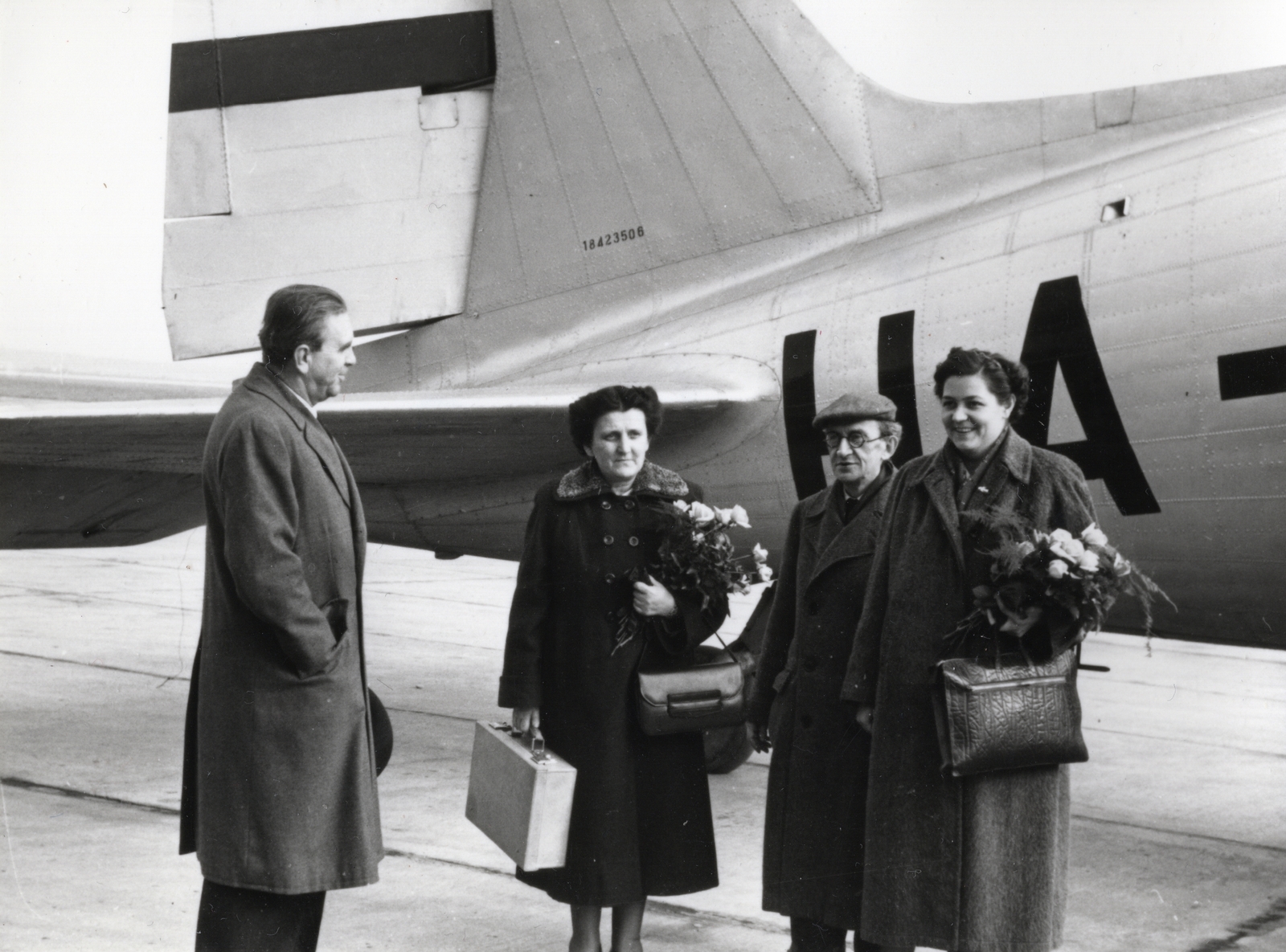 Hungary, Ferihegy (now - Ferenc Liszt) International Airport, Budapest XVIII., a MALÉV HA-LIB jelű Li-2P repülőgépe előtt balról Mihályfi Ernő, Andics Erzsébet, Lukács György, Bugár Jánosné, a Béke-Világtanács stockholmi rendkívüli ülésszakáról hazaérkező magyar küldöttség tagjai. A felvétel 1956. április 12-én készült., 1956, Bauer Sándor, airplane, airport, Lisunov-brand, handbag, bouquet, reception, Budapest, Fortepan #128506