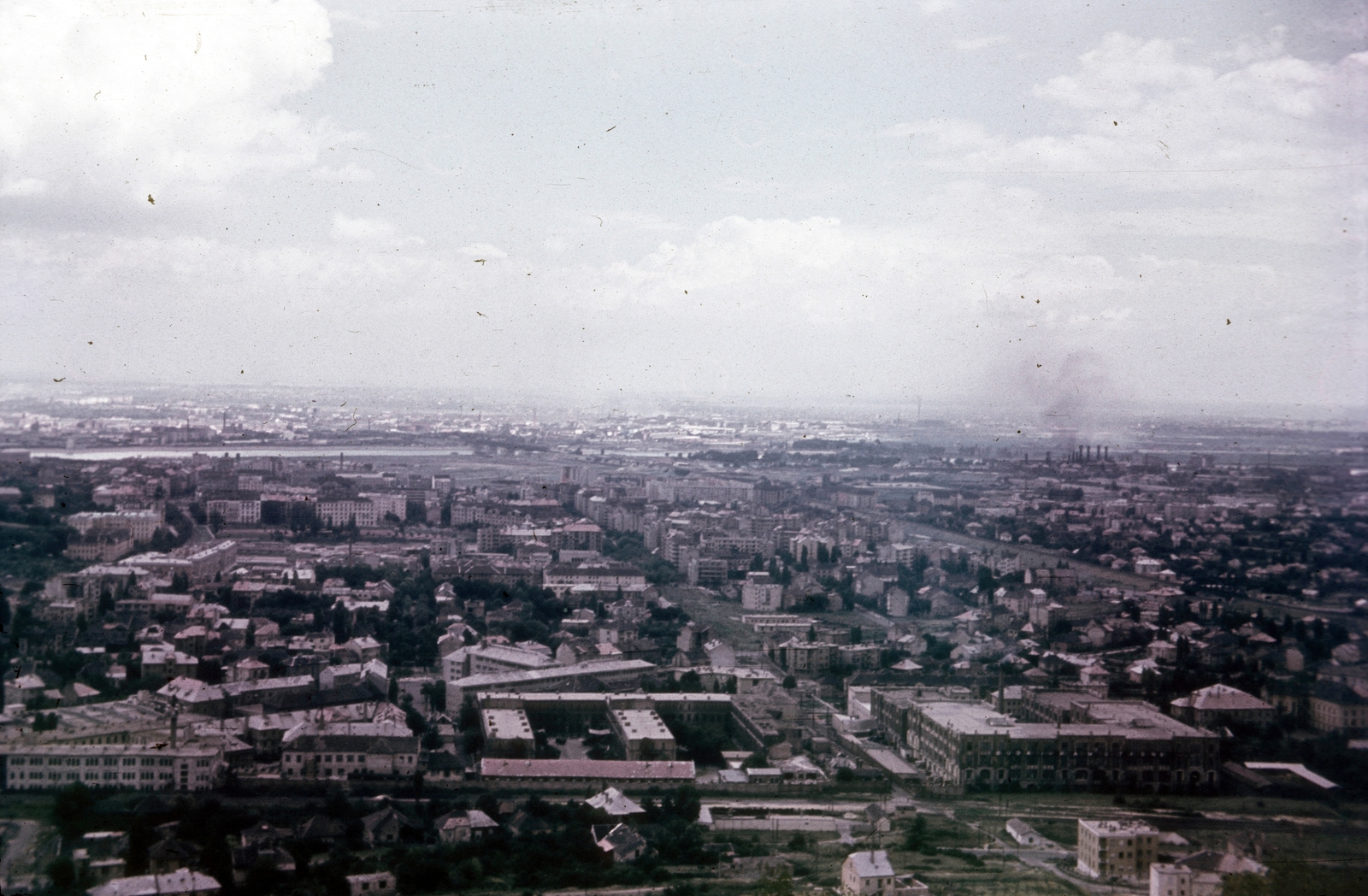 Magyarország, Budapest XI., kilátás a Sas-hegyről, keresztben a Déli vasút vonala, mellette az Alsóhegy utca, ide torkollik a Bocskai út. A jellegzetes hármas tagolású épületegyüttes jobb oldali szárnya a MOGÜRT irodaház. Az út jobb oldalán a Danúbia-selyemkikészítőgyár, a Kozmetikai és Háztartásvegyipari Vállalat és a Pamuttextilművek (később Dorottya udvar) épülete., 1959, Heinzely Béla, Budapest, Fortepan #129183