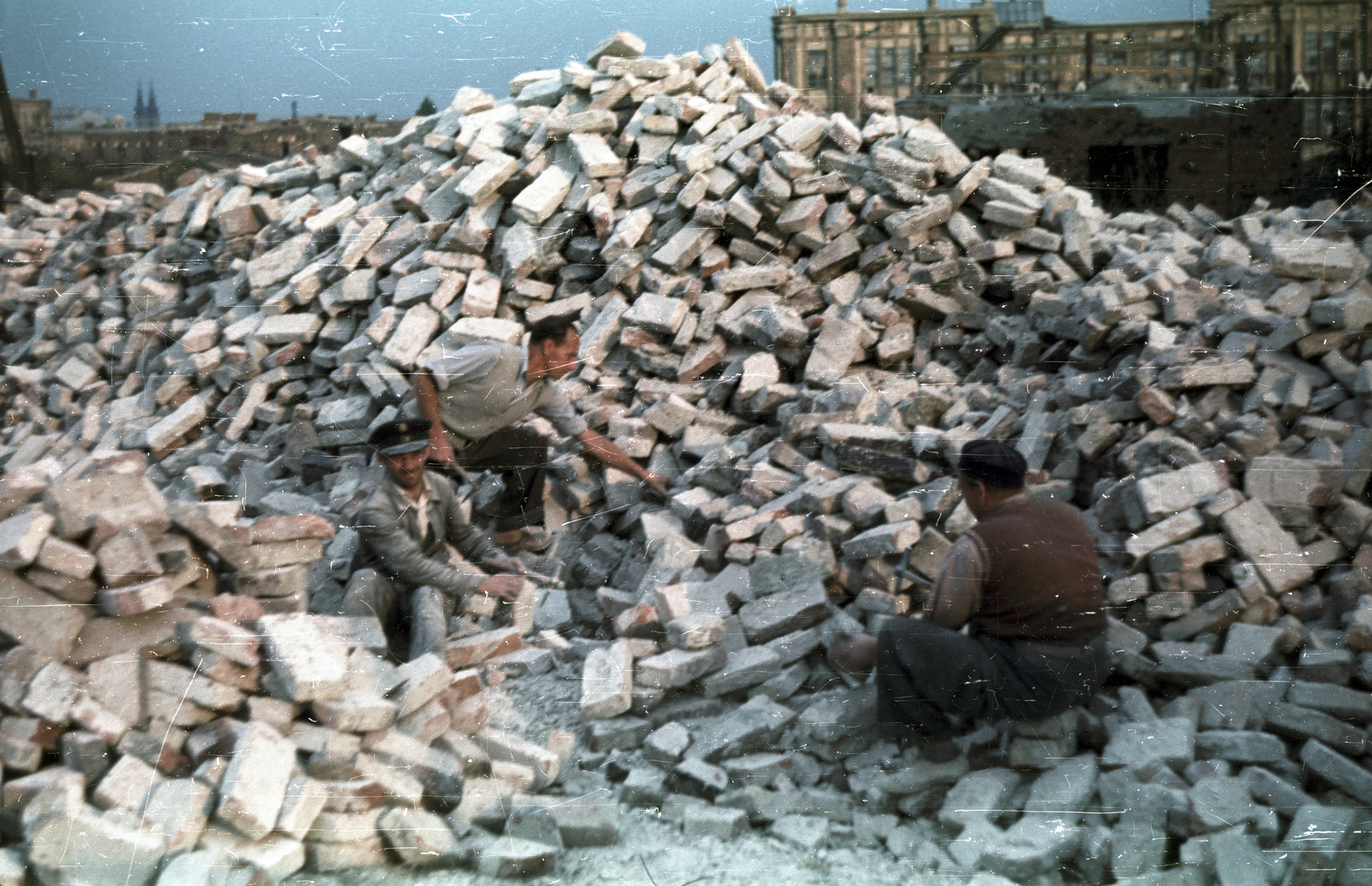 Magyarország, Budapest XI., bontott tégla tisztítása a Budaörsi út - Fehérló utca közötti területen, háttérben a Pamuttextilművek (később Dorottya udvar) épülete., 1959, Horváth Miklós dr, Budapest, Fortepan #129432