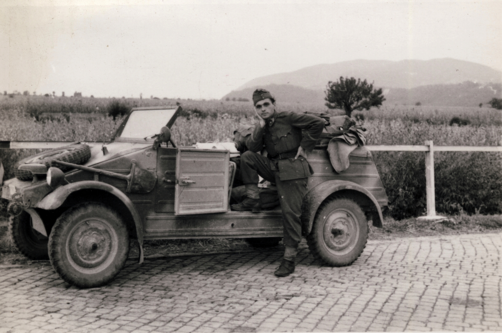 Ukrajna, a Nagyszőlős-Huszt országút Rakasz falu környékén, háttérben a Nagyszőlős fölött emelkedő Fekete-hegy., 1944, Kemenesi Gábor, Volkswagen-márka, automobil, ásó, terepminta, pótkerék, terepjáró, magyar katona, Volkswagen Kübelwagen, Bocskai sapka, Fortepan #129805