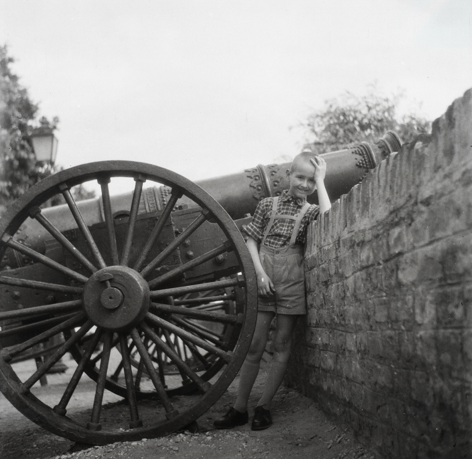 Magyarország, budai Vár, Budapest I., Tóth Árpád sétány a Hadtörténeti Múzeum előtt. Az Osztrák-Magyar Monarchia, Őfelsége Mária Terézia császárné és királyné nevű hadihajó legénysége által, az 1900. évi kínai Boxerlázadás során zsákmányolt történelmi ágyúk., 1954, Lossonczy Miklós, Budapest, képarány: négyzetes, kisfiú, könyökölni, várfal, ágyú, Fortepan #130038