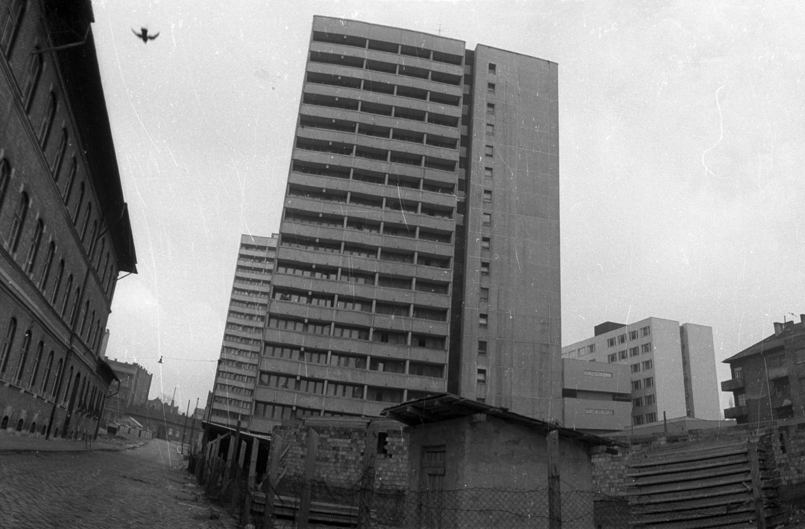 Magyarország, Budapest VIII., Jázmin utca a Füvészkert (Szigetvári) utca felé nézve, balra a Jázmin utcai általános iskola (később Wekerle Sándor Üzleti Főiskola és Atalanta Üzleti Szakgimnázium). A Tömő utcai toronyházaktól jobbra a SOTE Szemészeti Klinikája (később Semmelweis Egyetem Onkológiai Központ), előtérben a Tömő utcai óvoda épikezése., 1973, Vizsnyiczai Erzsébet, Budapest, Fortepan #130528