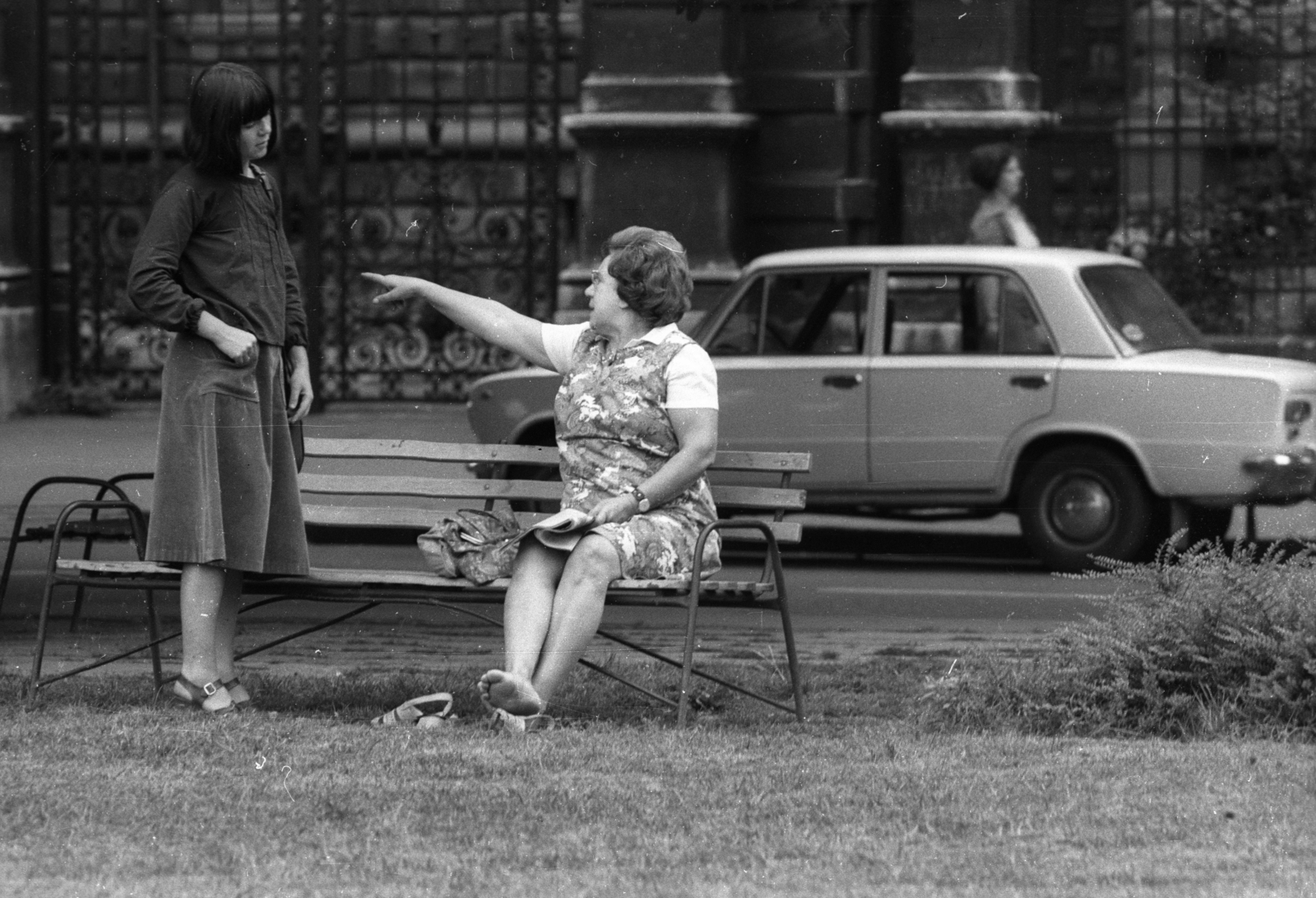 Magyarország, Budapest VI., az Andrássy út (Népköztársaság útja) 83-85. számú épület Kodály körönd felőli kovácsoltvas kapuja., 1975, Vizsnyiczai Erzsébet, Budapest, pad, nők, mutatni, mezítláb, szoknya, Fortepan #130665