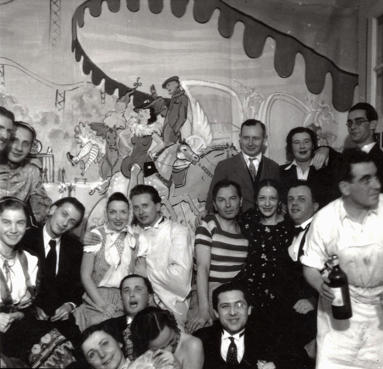 Hungary, Budapest II., Gül Baba utca 36., házavató Péter Andráséknál 1938. január 15-én. Bal oldalon Kolozsvári Grandpierre Emil író, előtte Gyarmati Fanni és Radnóti Miklós költő, mellettük Péter Andrásné és Ortutay Gyula néprajzkutató. Előrébb Halász Gábor író és monoklival Joó Tibor irodalomtörténész. Jobb oldalon fehér köténnyel Péter András művészettörténész (házigazda), mellette Hevesi András író, fölötte Reitzer Béla szociológus., 1938, Paczolay család, celebrity, fresco, Budapest, striped dress, tableau, Fortepan #131516