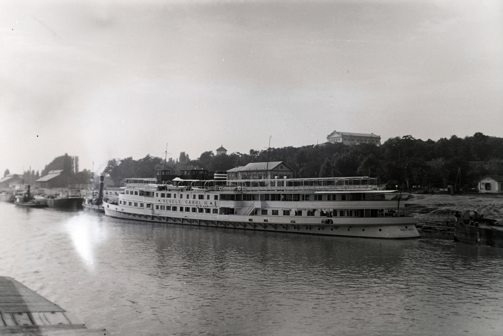 Romania, Drobeta-Turnu Severin, (ekkor Turnu Severin), kikötő, fent a Theodor Costescu Kultúrpalota látható. Az NFR Regele Carol II (épült: 1936.) nevű román személyszállító gőzhajója. Korának legnagyobb dunai hajója volt. Leltári jelzet: MMKM TFGY 2017.10.35, 1936, Magyar Műszaki és Közlekedési Múzeum / Archívum / Negatívtár / özv Venczel Jánosné gyűjteménye, Fortepan #132305