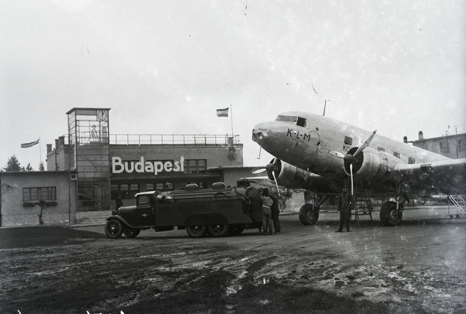 Hungary, Mátyásföld Airport, Budapest XVI., a KLM holland királyi légitársaság indiai járatának Douglas DC-2- 115 E típusú utasszállító repülőgépe az átépített repülőtéren. Balra az üvegezett meteorológiai észlelő torony és fogadócsarnok. Leltári jelzet: 1154, 1936, Magyar Műszaki és Közlekedési Múzeum / Archívum / Negatívtár / Magyar Nemzeti Múzeum Történeti Képcsarnok gyűjteménye, KLM Royal Dutch Airlines, Budapest, Douglas-brand, Fortepan #132557