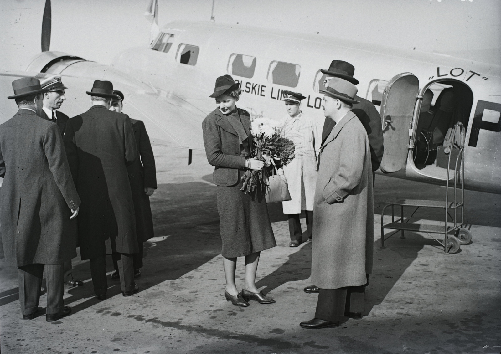 Hungary, Budaörs Airport, Budapest XI., a lengyel légforgalmi társaság amerikai kétmotoros, Lockheed gyártmányú forgalmi repülőgépe. A géppel érkezett Varsóból Michał Łubieński lengyel külügyminiszter 1938. október 19-én. Leltári jelzet: 1202&#10;, 1938, Magyar Műszaki és Közlekedési Múzeum / Archívum / Negatívtár / Magyar Nemzeti Múzeum Történeti Képcsarnok gyűjteménye, airplane, Lockheed-brand, bouquet, Budapest, aircraft steps, hands in pockets, Lockheed Electra, Fortepan #132600