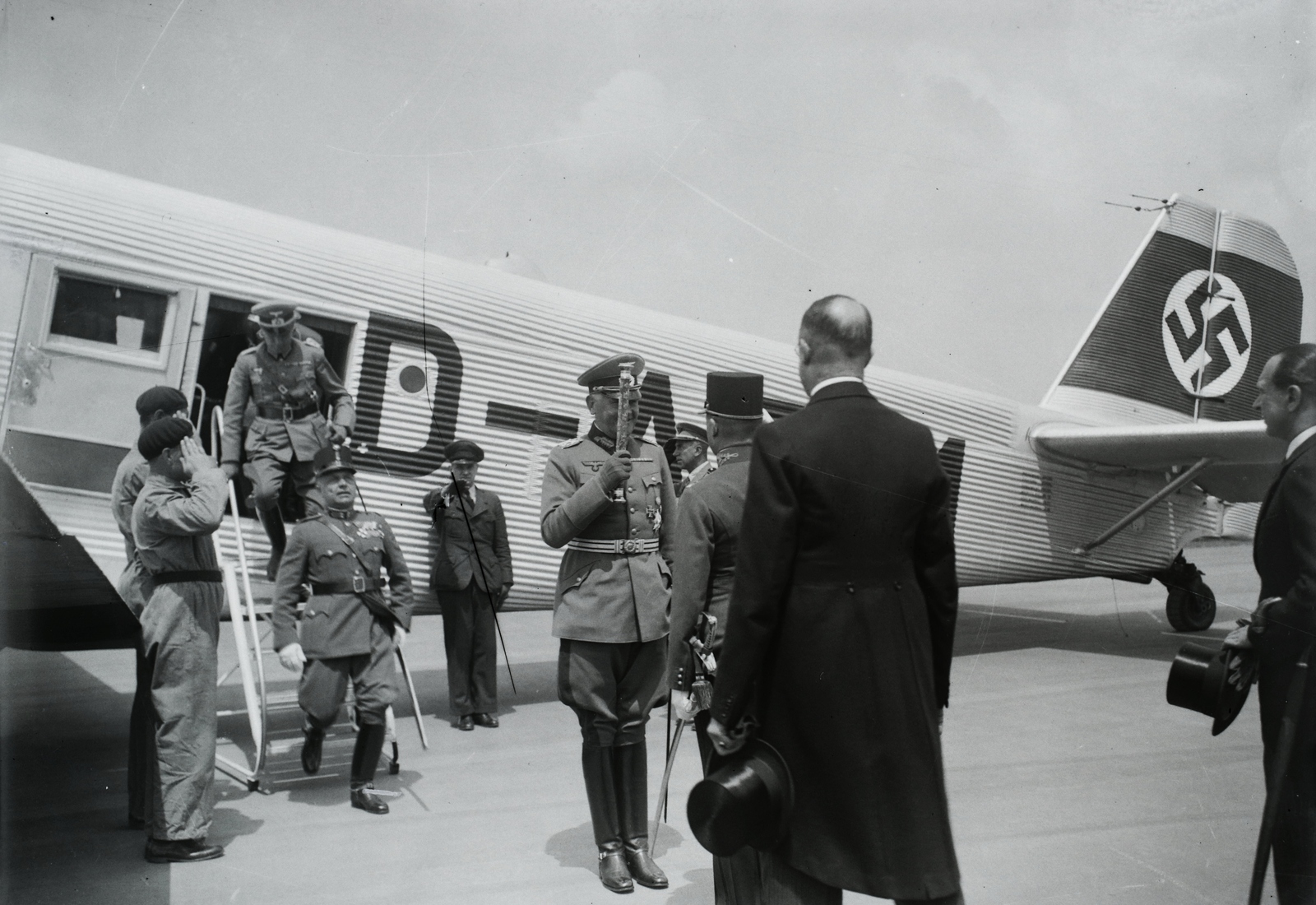 Hungary, Budaörs Airport, Budapest XI., középen marsalbottal a kezében Blomberg tábornagy, német hadügyminiszter, akit érkezésekor Rőder Vilmos honvédelmi miniszter üdvözöl. Háttérben egy Junkers Ju 52 típusú repülőgép. A felvétel 1937. június 28-án készült. Leltári jelzet: 1384, 1937, Magyar Műszaki és Közlekedési Múzeum / Archívum / Negatívtár / Magyar Nemzeti Múzeum Történeti Képcsarnok gyűjteménye, Junkers-brand, Budapest, Fortepan #132685
