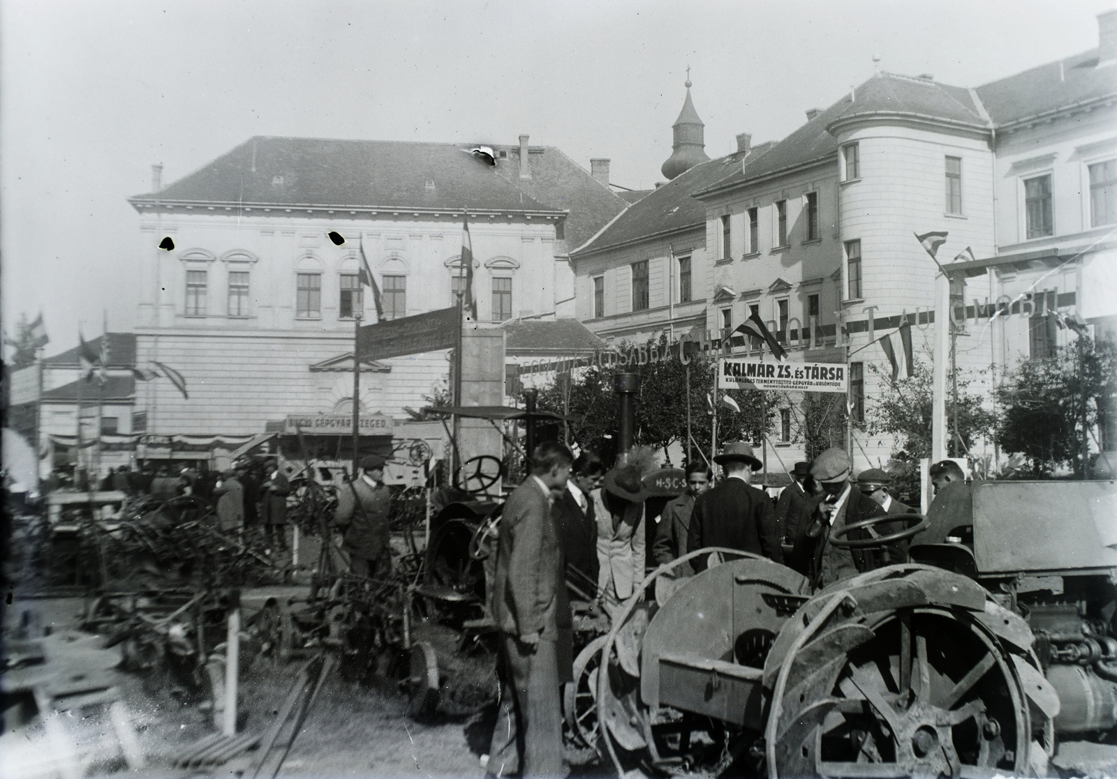 Hungary, Szentes, Szent Imre herceg (Horváth Gyula) utca, a Horváth Mihály Gimnázium udvara. A Tiszavidéki Mezőgazdasági, Ipari, Kereskedelmi és Kulturális Kiállítás mezőgazdasági gépbemutatója. A tető fölött a katolikus templom tornya látszik. Leltári jelzet: 29826, 1927, Magyar Műszaki és Közlekedési Múzeum / Archívum / Negatívtár / Pölös István gyűjteménye, Czakó Ferenc, agricultural machine, Fortepan #132931