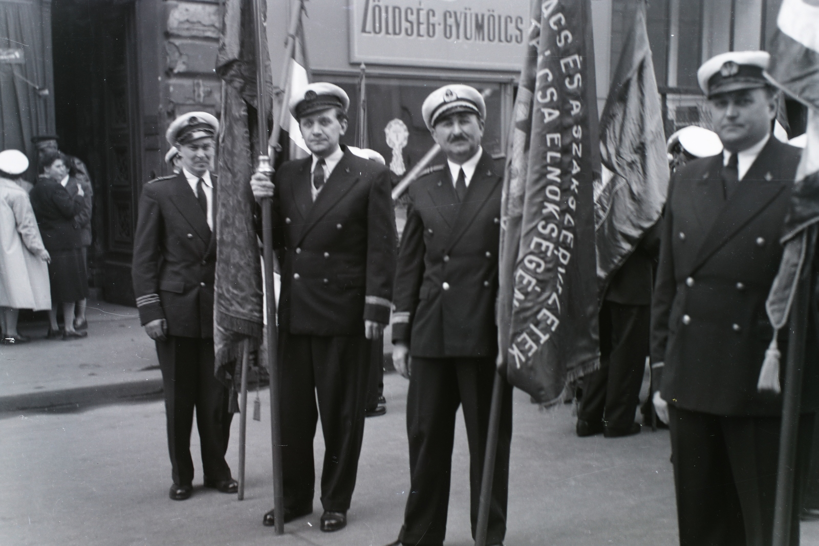 Hungary, Budapest V., Apáczai Csere János utca 13. és jobbra a 11. szám, a MESZHART (később MAHART) Igazgatóság épülete. A hajótársaság tisztjei készülődnek a május 1-i felvonulásra. Leltári jelzet: 30623., 1951, Magyar Műszaki és Közlekedési Múzeum / Archívum / Negatívtár / Szollár Ferenc gyűjteménye, Budapest, flag, soldier, march, officer, Fortepan #133072