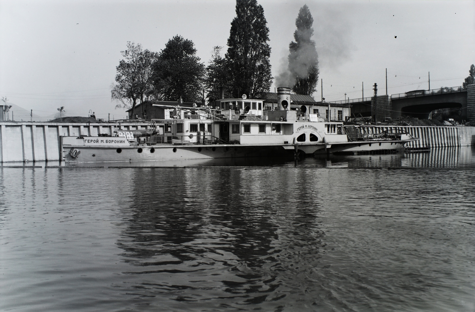 Hungary, Óbuda, Budapest III., Óbudai Hajógyár, a Geroj Boronyin (épült: 1956.) oldalkerekes vontató gőzhajó a Hajógyári-öbölben, háttérben az Árpád (Sztálin) híd. Leltári jelzet: 21632, 1956, Magyar Műszaki és Közlekedési Múzeum / Történeti Fényképek Gyűjteménye / Óbudai Hajógyár gyűjteménye, Budapest, Cyrillic alphabet, Fortepan #133090