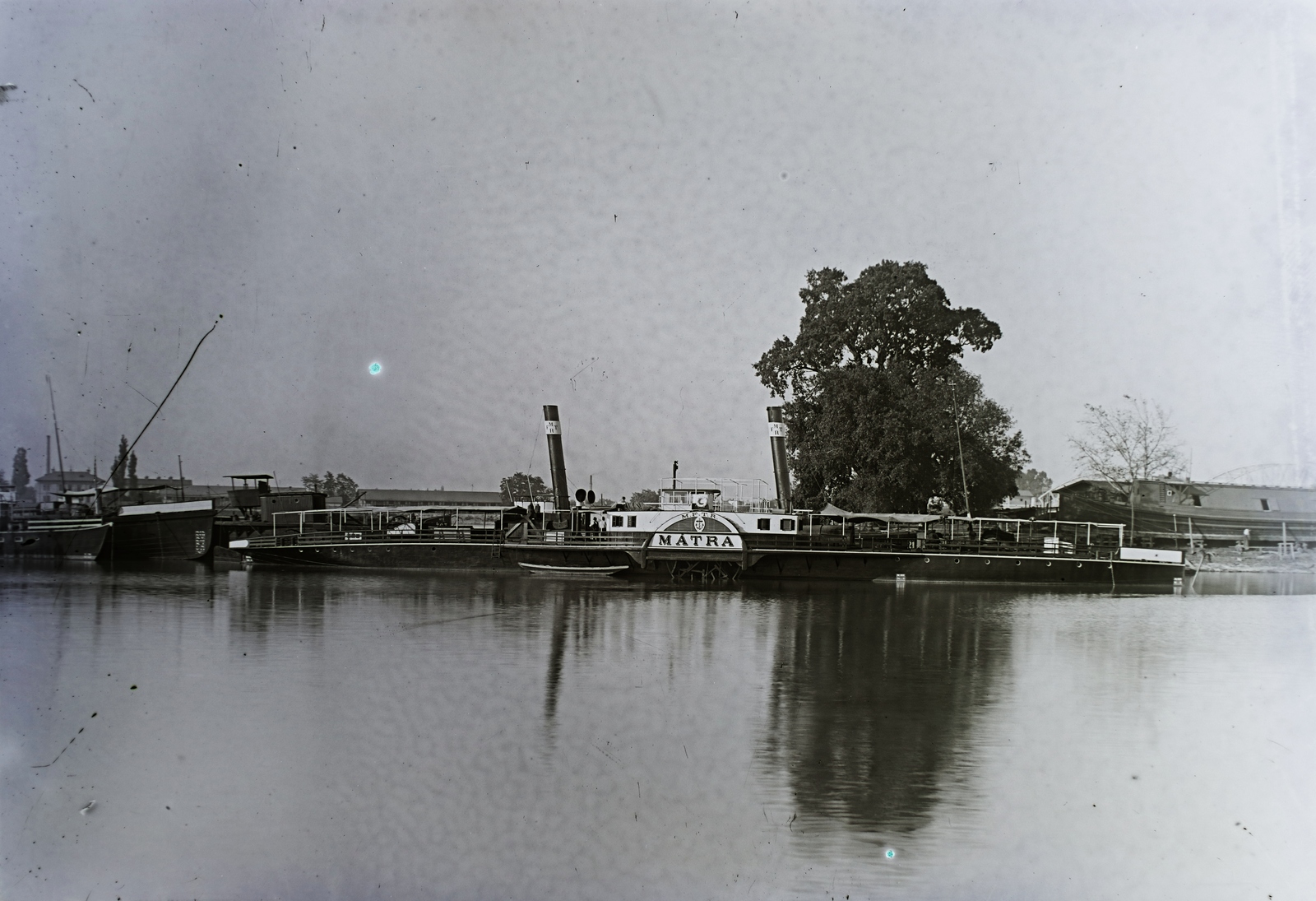 Slovakia, Komarno, Kis-Duna-ág, Mátra MFTR oldalkerekes vontató gőzhajó (épült: 1896.) a hajóműhely előtt. A kép jobb szélén az Erzsébet híd sziluettje látszik. Leltári jelzet: N102, 1932, Magyar Műszaki és Közlekedési Múzeum / Archívum / Negatívtár / özv Venczel Jánosné gyűjteménye, steamboat, Mátra-ship, Fortepan #133118