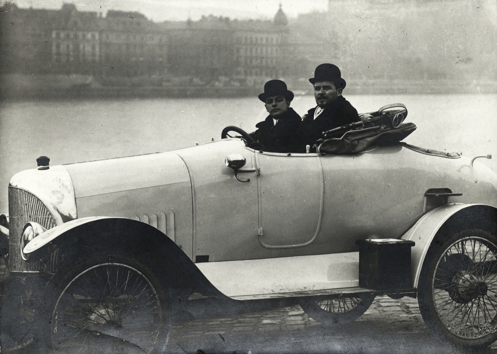 Hungary, Budapest V.,Budapest I., pesti alsó rakpart, a Duna túlprtján a Várkert rakpart házai. Ford 18 / 24 HP special egyedi építésű sportkocsi. A volánnál Vértes (később Vértessy) Vilmos, mellette Baráth Leó László a gépkocsi építtetője és tulajdonosa., 1913, Magyar Műszaki és Közlekedési Múzeum / Témagyűjtemény / Vértes Vilmos István gyűjteménye, car race, automobile, Budapest, Fortepan #133359