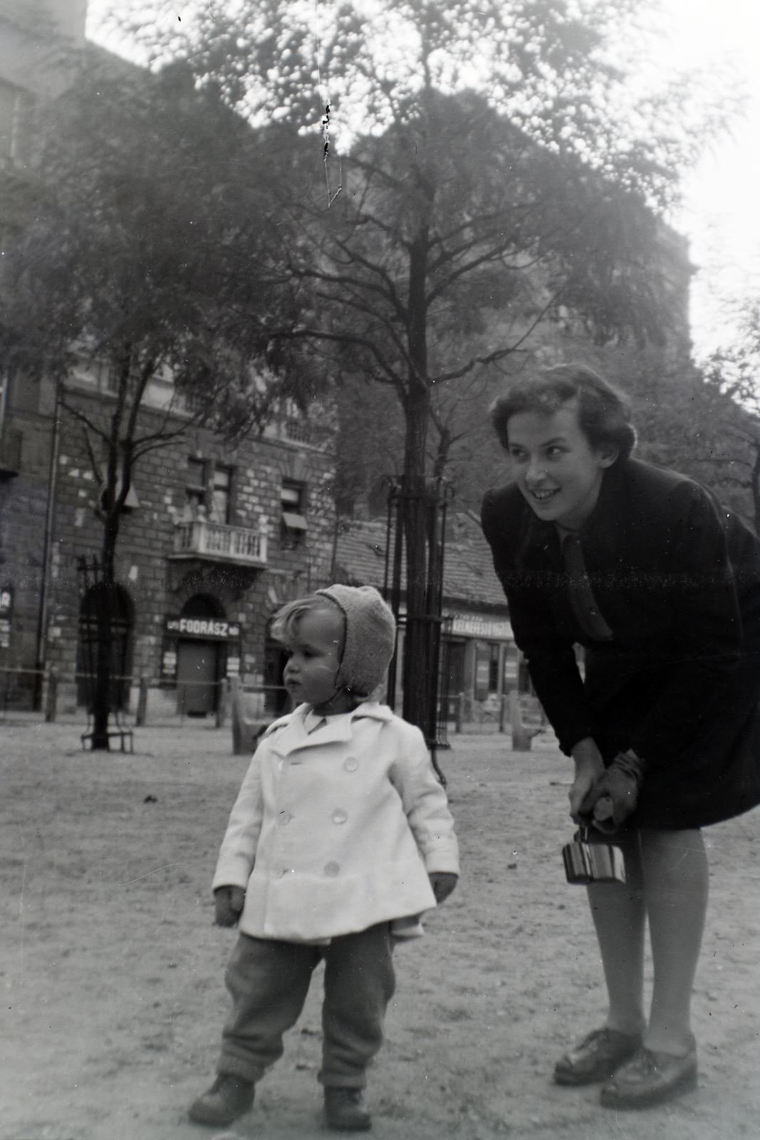 Hungary, Budapest VIII., Horváth Mihály (Mária Terézia) tér, a háttérben az 5., 4. és 3. számú ház., 1946, Barna Imre, Budapest, lady, wood, kid, sign-board, viewing, Fortepan #133391