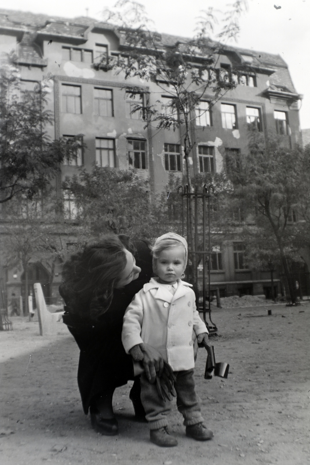Hungary, Budapest VIII., Horváth Mihály (Mária Terézia) tér, a háttérben a 8. szám alatti Gyakorló Iskola (később Fazekas Mihály Gyakorló Általános Iskola és Gimnázium)., 1946, Barna Imre, Budapest, lady, wood, kid, Fortepan #133396
