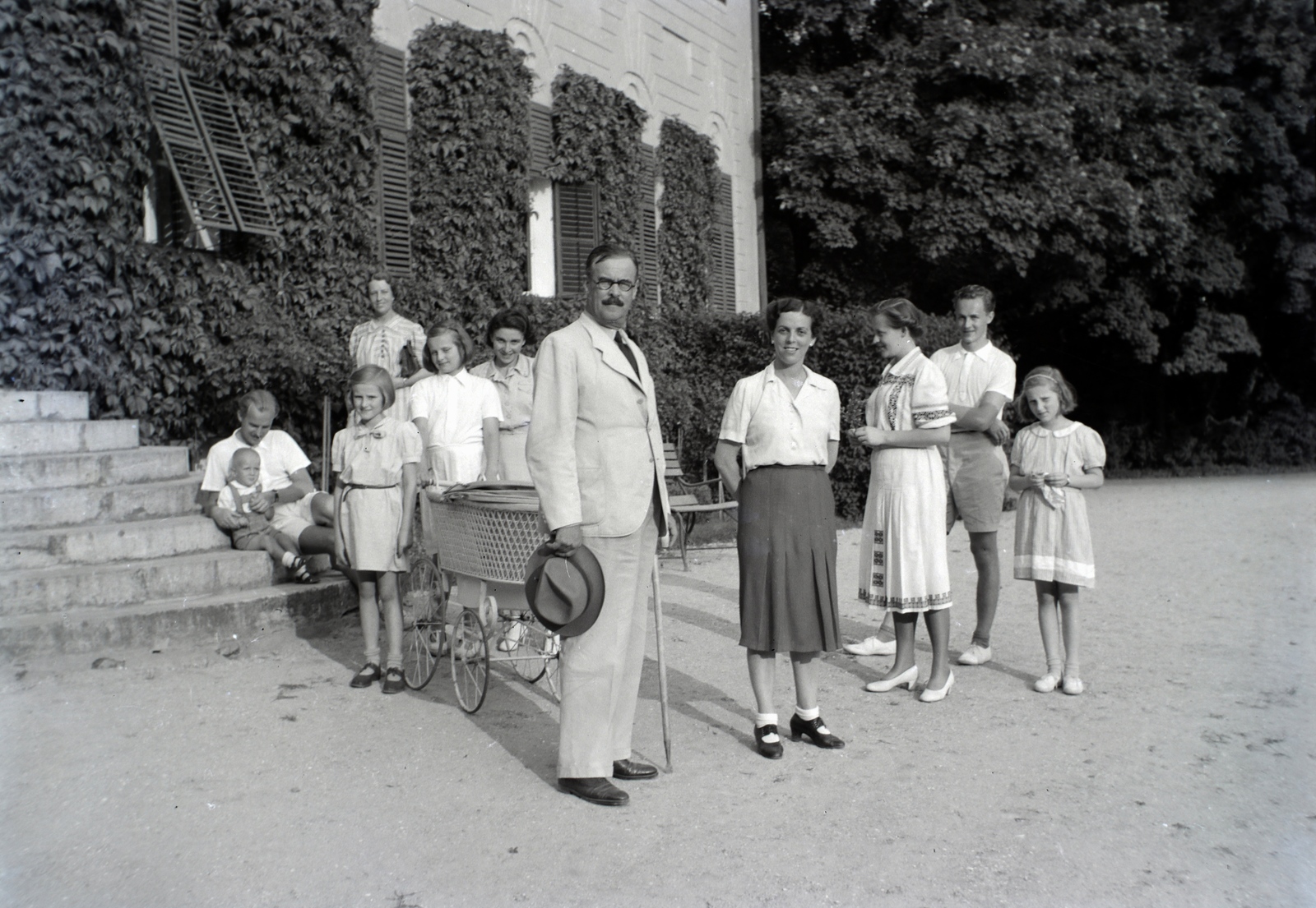 Hungary, Bóly, (Németbóly), Batthyány-Montenuovo kastély. Elöl id. Manninger Gusztáv Adolf mezőgazdász a Montenuovo-birtokok jószágkormányzója. Balra a lépcsőn ül Dr. Manninger Gusztáv Adolf entomológus, jobbra áll Manninger Jenő a későbbi sebész professzor., 1941, Fortepan/Album018, baby carriage, sitting on stairs, hat in hand, Fortepan #134614