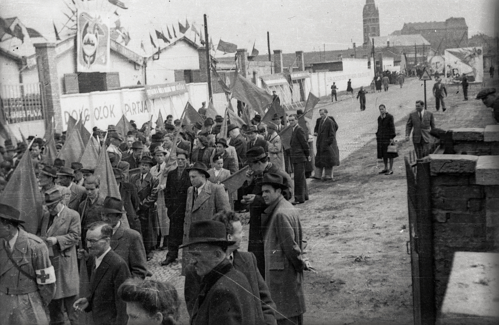 Hungary, Budapest VIII.,Budapest XIV., Dózsa György út, háttérben a Lisieux-i Szent Teréz-templom (Törökőri templom) a Kerepesi úton. Április 4-i ünnepség résztvevői., 1949, Fortepan/Album021, Budapest, mass, men, flag, armband, Fortepan #134822