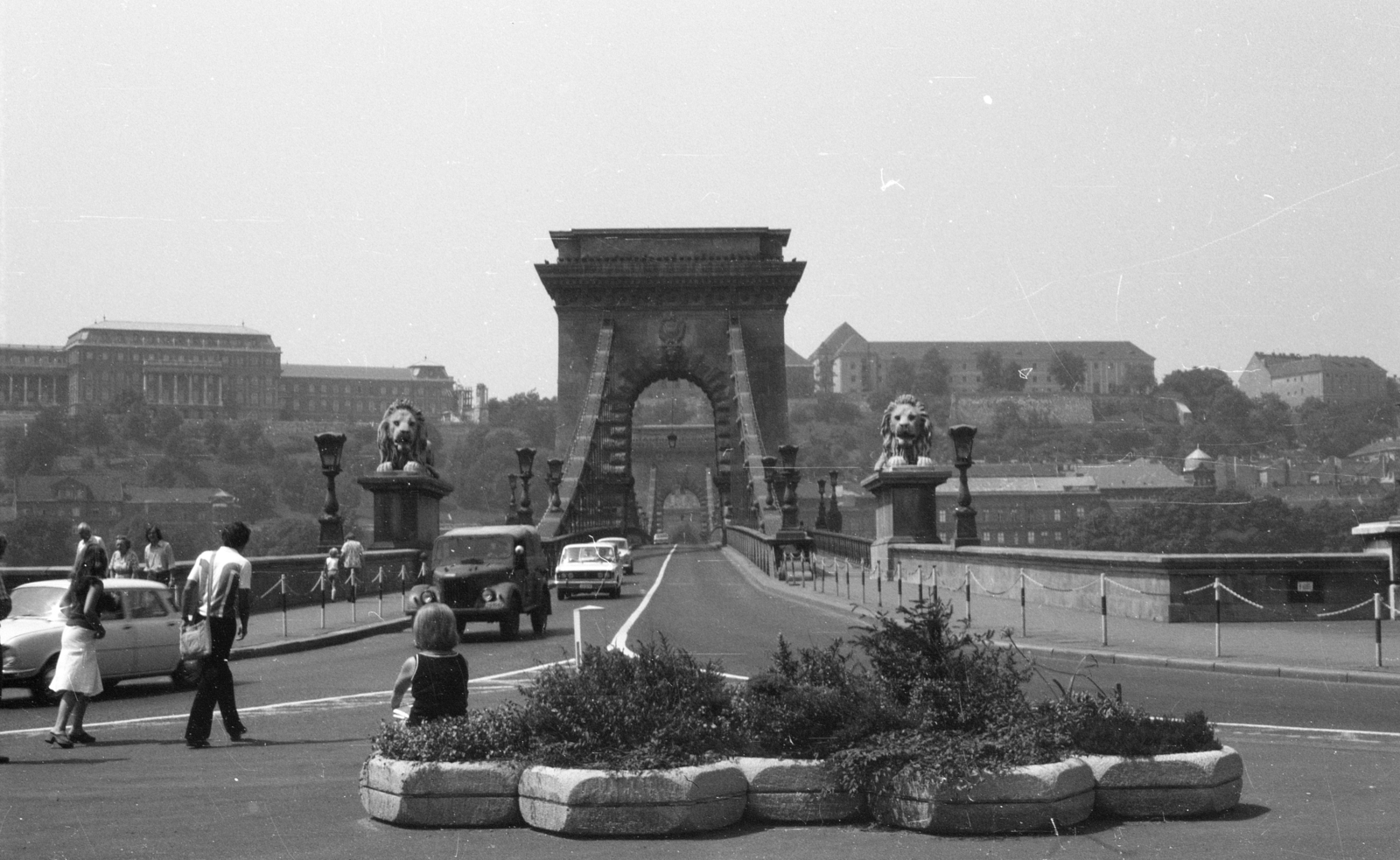 Magyarország, Budapest V.,Budapest I., Széchenyi István (Roosevelt) tér, szemben a Széchenyi Lánchíd, a háttérben balra fenn a Budavári Palota (korábban Királyi Palota)., 1984, Fortepan/Album020, híd, kőoroszlán, Budapest, függőhíd, Duna-híd, William Tierney Clark-terv, Fortepan #136034