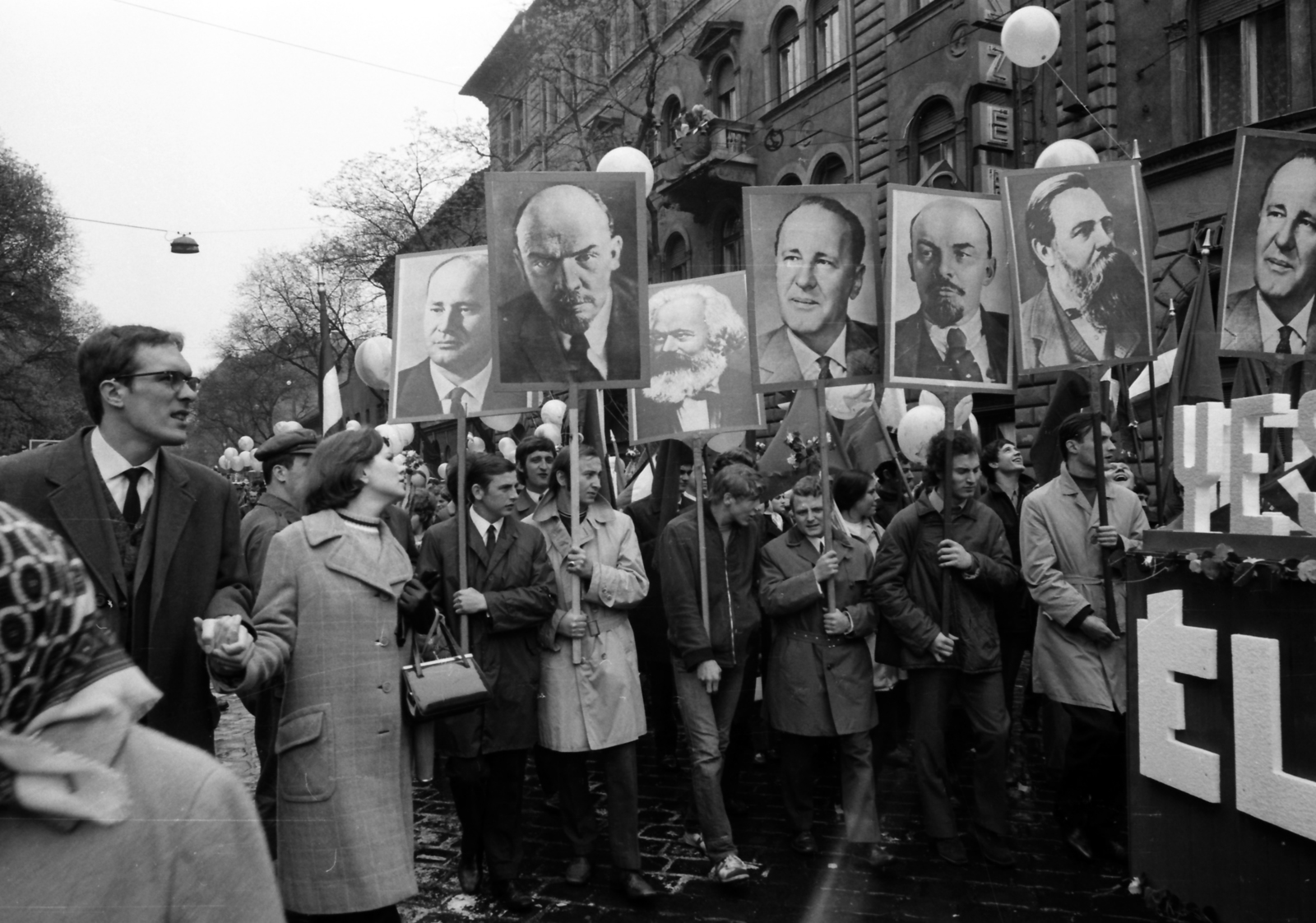 Magyarország, Budapest VII., május 1-i felvonulók a Dózsa György út 54. számú ház előtt., 1974, szitakri, Lenin-ábrázolás, május 1, Karl Marx-ábrázolás, Friedrich Engels-ábrázolás, Budapest, Kádár János-ábrázolás, pódiumautó, Fortepan #136169