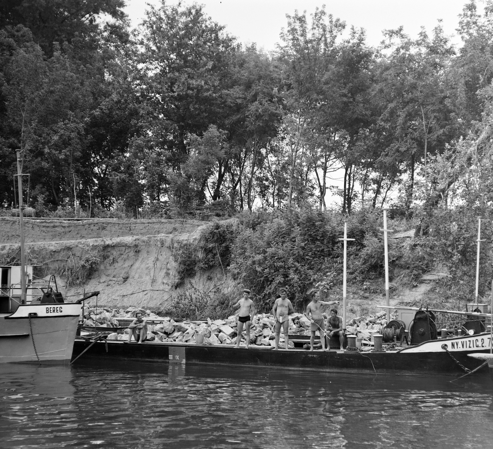 Hungary, a partfal megerősítésén dolgozók horgásznak a kőszállító uszályról. A felvétel a Tiszán Tuzsér és Szeged között, az ERDÉRT vállalat telepétől a fafeldolgozó üzemekhez leúsztatott farönköket vontató Gabi nevű hajóról készült., 1967, Szalay Zoltán, Fortepan #138003