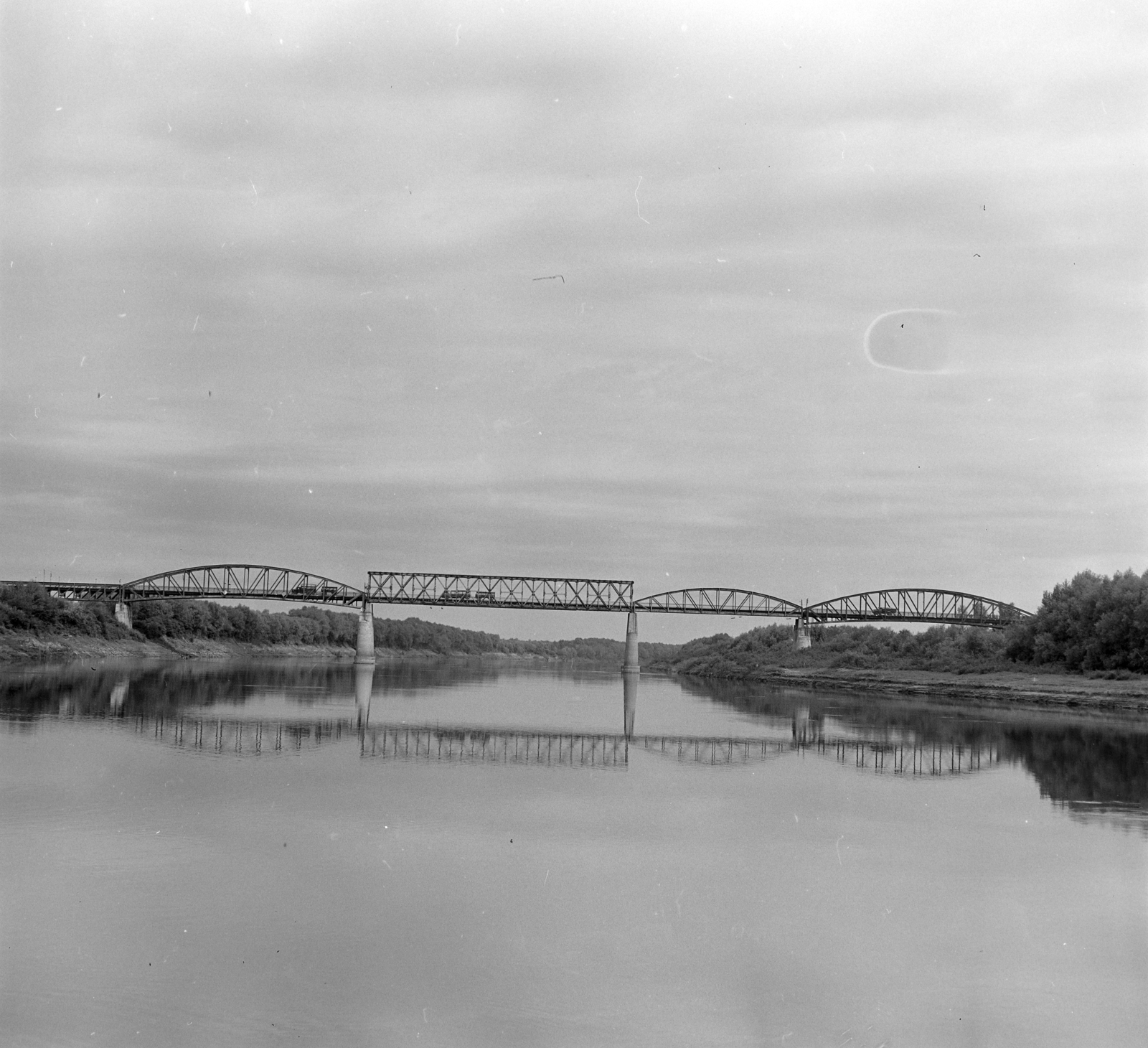 Hungary, Szentes, a Szentes - Csongrád közötti vasúti Tisza-híd. A felvétel a Tiszán Tuzsér és Szeged között, az ERDÉRT vállalat telepétől a fafeldolgozó üzemekhez leúsztatott farönköket vontató Gabi nevű hajóról készült., 1967, Szalay Zoltán, Fortepan #138020