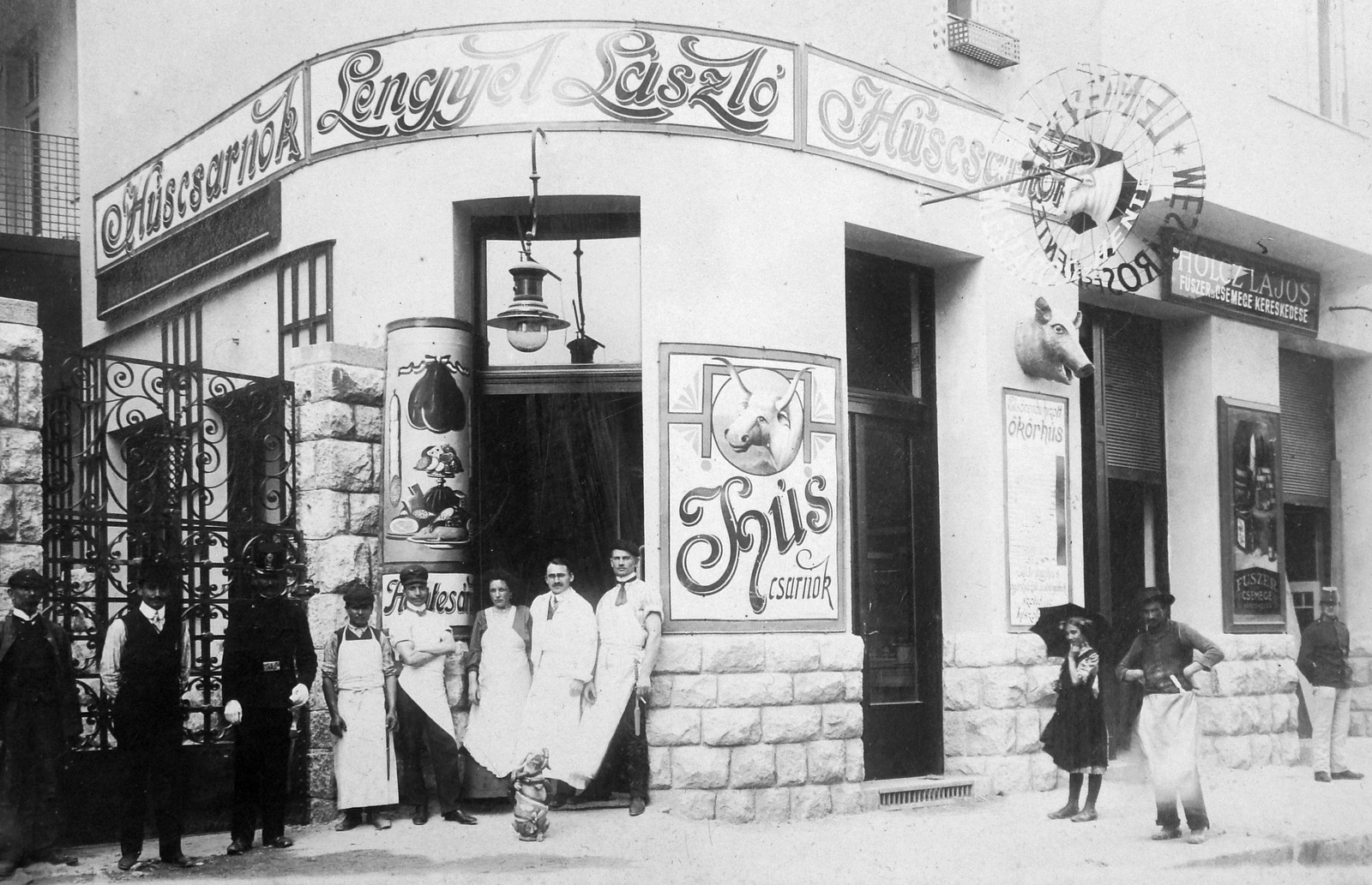 Hungary, Budapest XI., Budafoki út 41/a., 1916, Fortepan, Budapest, hands behind the back, akimbo, arms crossed over the chest, vendor, tableau, store display, ashlar, sign-board, grocery store, meat apron, butcher, standing in door, umbrella, Fortepan #13851