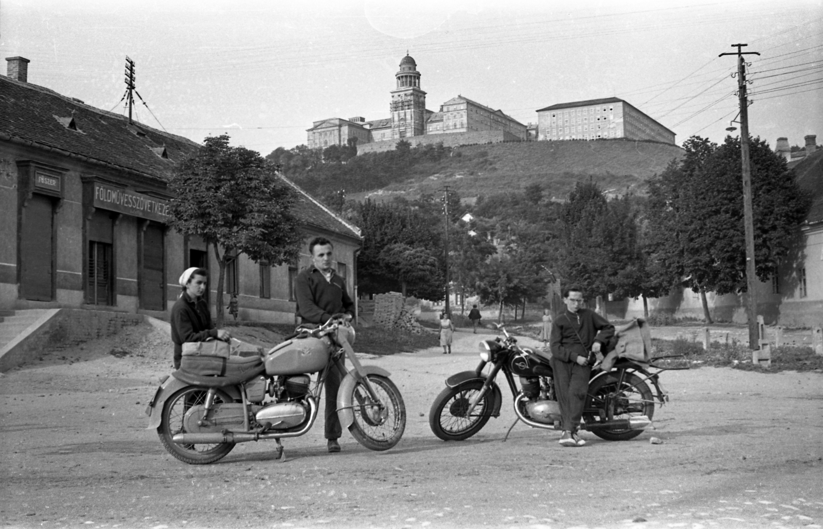 Hungary, Pannonhalma, (Győrszentmárton), Mátyás király út, szemben a Szent Márton-hegy és a Pannonhalmi Bencés Főapátság., 1960, Morvay Kinga, motorcycle, Benedictines, Izh-brand, farmers' co-operative, Fortepan #140461