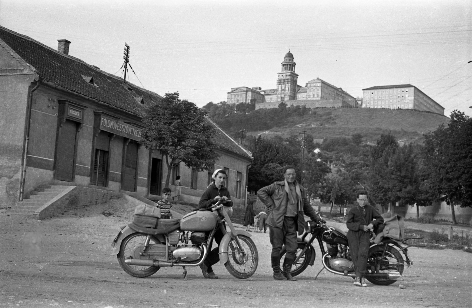 Hungary, Pannonhalma, (Győrszentmárton), Mátyás király út, szemben a Szent Márton-hegy és a Pannonhalmi Bencés Főapátság., 1960, Morvay Kinga, motorcycle, Benedictines, Izh-brand, farmers' co-operative, Fortepan #140462